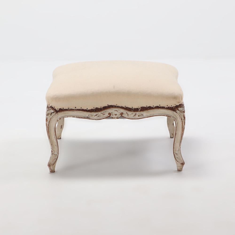 French painted Louis XV style stool having a shaped frame with natuaralistic carvings C 1890.