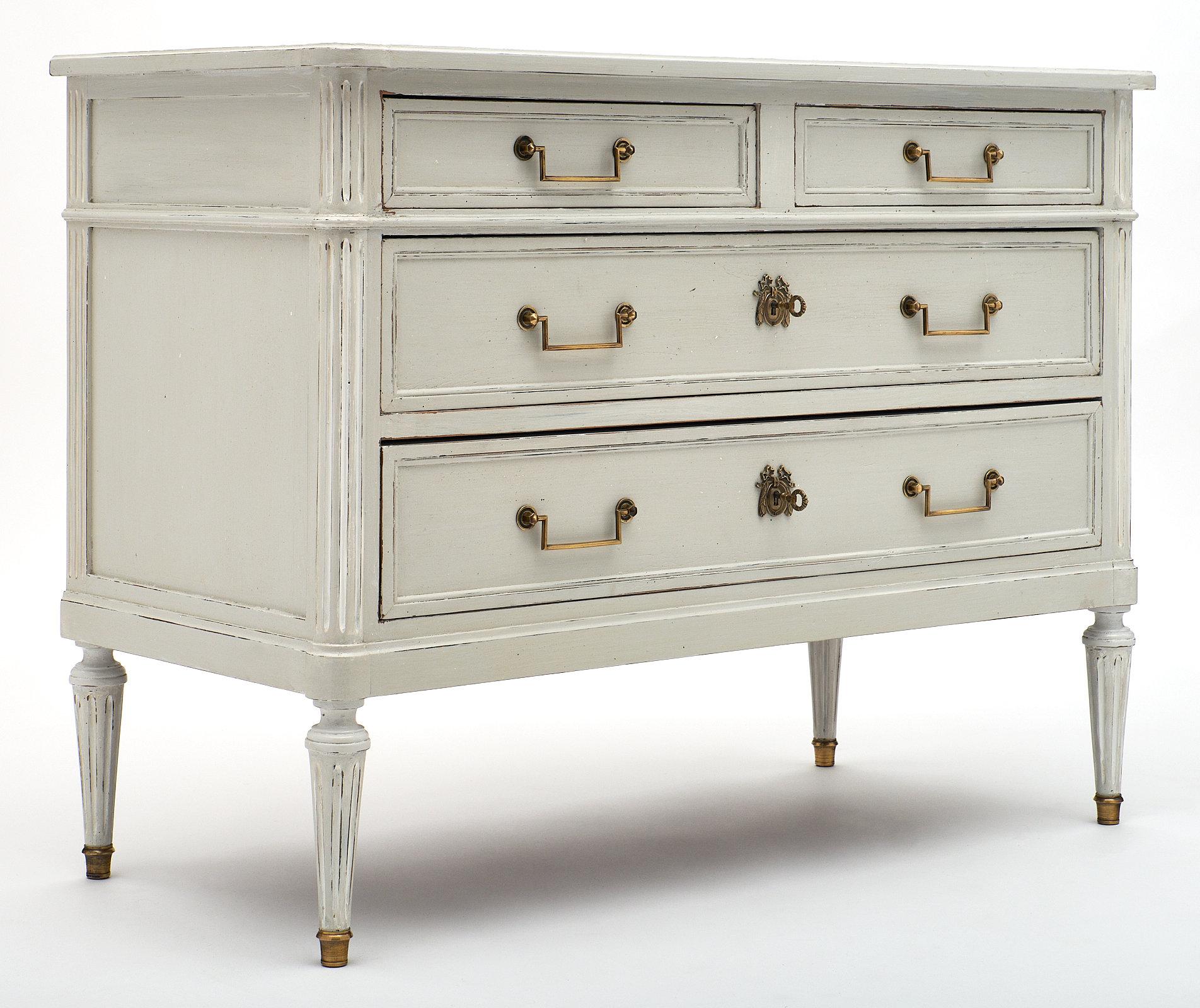 French painted Louis XVI style chest Louis XVI style French painted chest made of solid mahogany. This piece has been hand-painted a gray trianon color and features brass hardware and feet. We love the functionality of the four dovetailed drawers.
