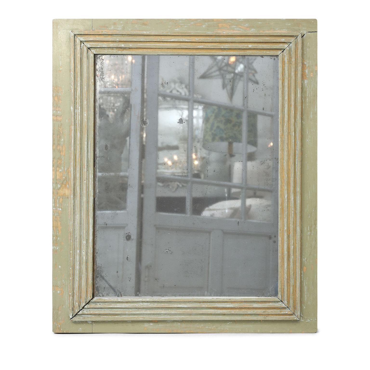 French painted mirror, dating to the early 19th century. Original (or early) mercury glass mirror plate surrounded by a hand carved fluted border. Mirror glass shows expected spots due to wear and age. Along with a gorgeous subtle 'diamond dust'