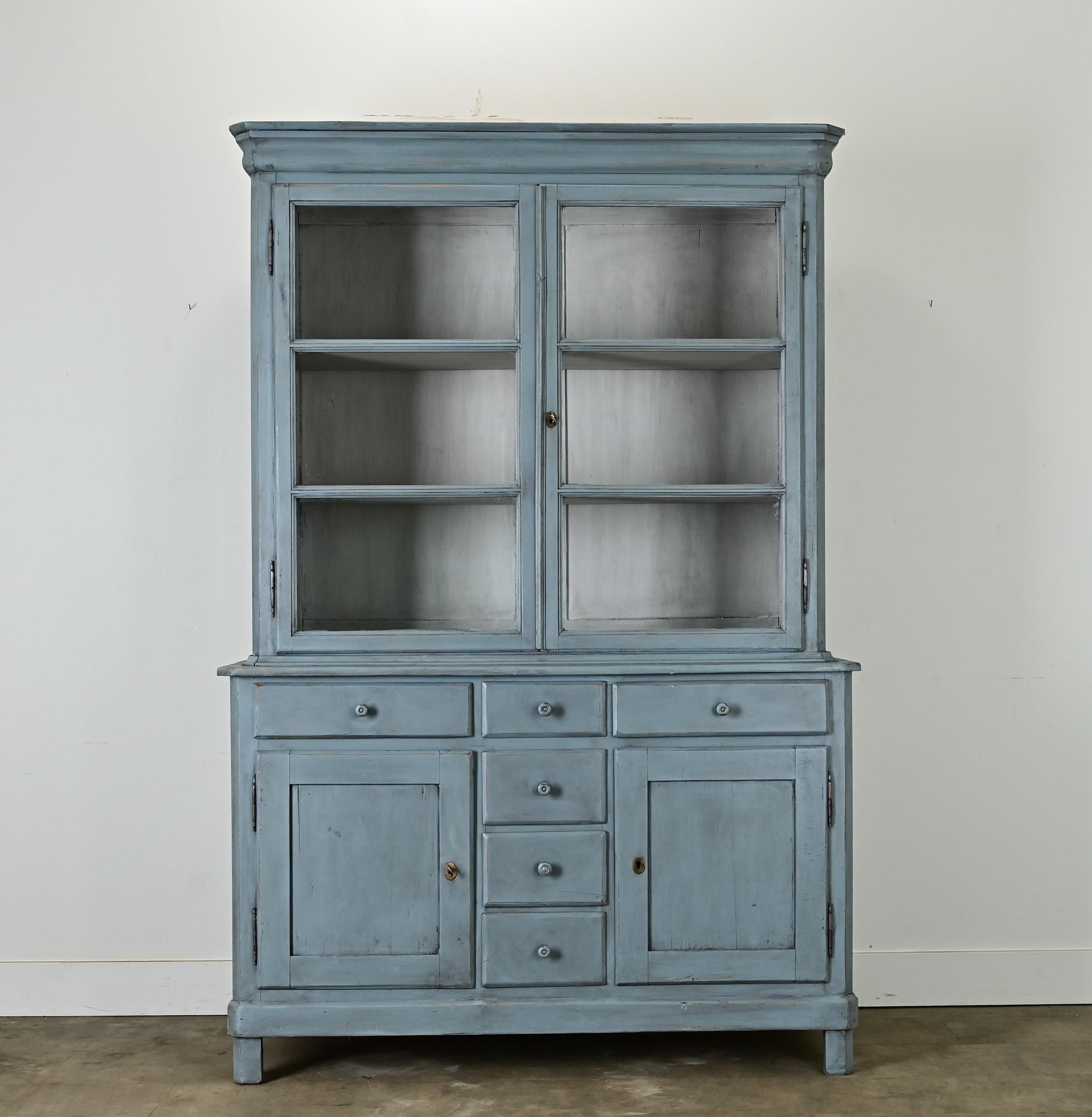 Questo buffet a deux corps o bibliotheque in pino massiccio ha una recente verniciatura blu francese. Il mobile superiore ha una coppia di ante in vetro che si aprono con una serratura funzionante e una chiave per accedere a un interno dotato di due