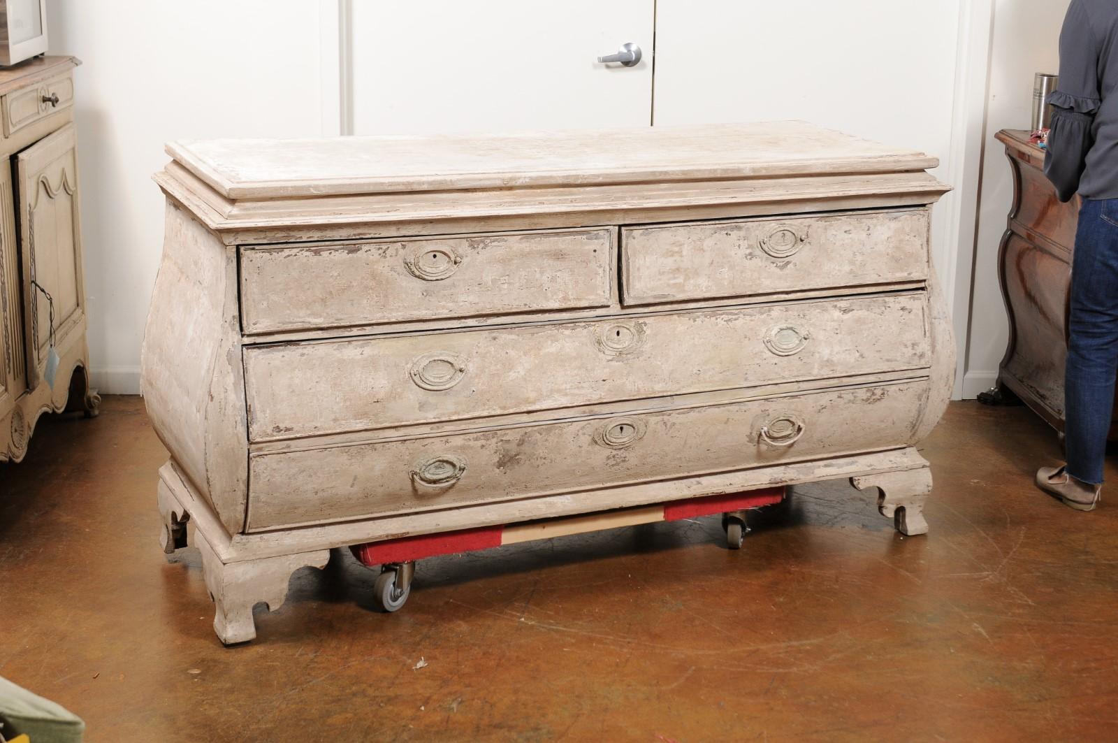 A large French Rococo style hand painted bombé chest-of-drawers from the 19th century with raised top and four drawers. This exquisite French painted bombé dresser features a rectangular raised top sitting above four drawers. These drawers (two