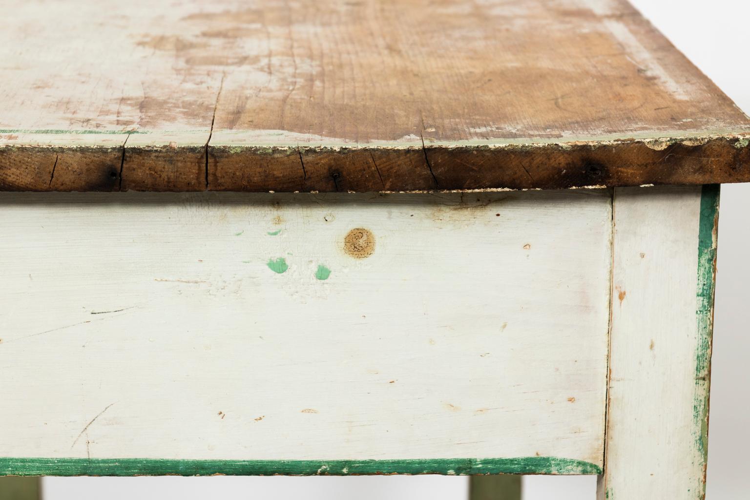 French green painted two-tier table with one drawer, plain tapered legs, and a bottom shelf, circa 19th century. The piece is in a distressed, antique finish.
 