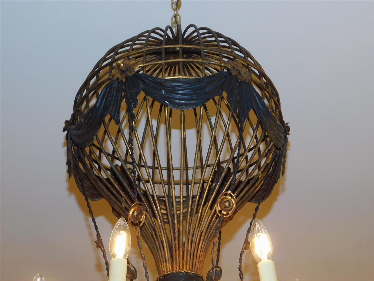 Lustre fantaisiste en fer peint et en fer doré avec médaillon en forme de guirlande de feuillage.  Le lustre comporte six bras électrifiés et était à l'origine alimenté par des bougies. Fin du 19e siècle.