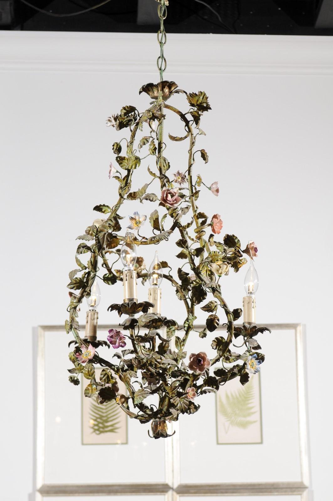A French painted tôle bell-shaped four-light chandelier from the 19th century, with hand painted porcelain flowers. Born in France during the 19th century, this charming painted tôle chandelier captures our attention with its green foliage,