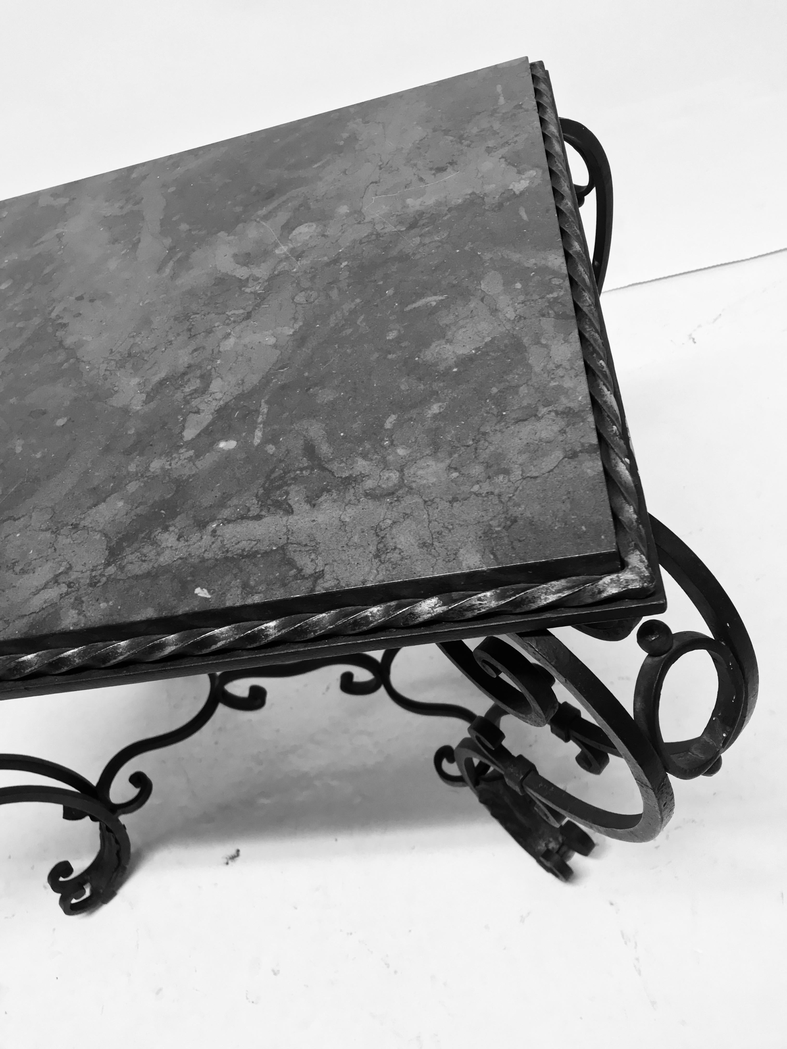 A French painted and gilded wrought iron occasional table with a polished blue-limestone top. The paint is a very dark green.