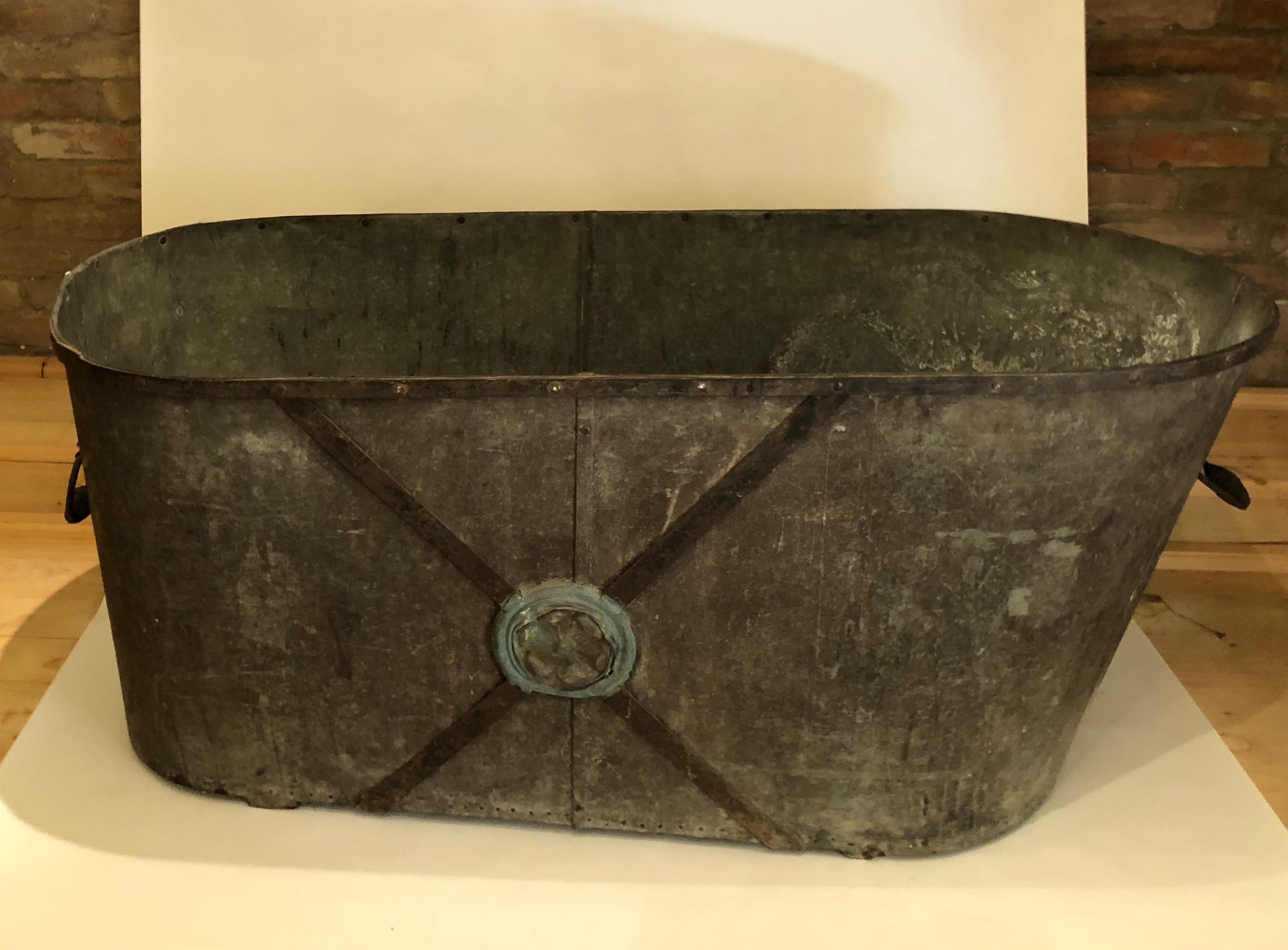 This French zinc bathtub is in original condition: without a drainage hole, with a wood subframe, two handles and beautiful blue painting and decoration on both sides. Seems to be watertight.
The piece has a solid construction and would need just a