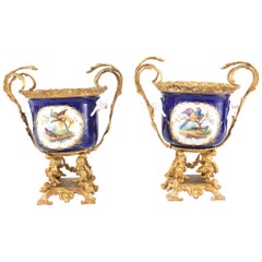 Coppia francese di urne / vasi in porcellana montati in bronzo dorato