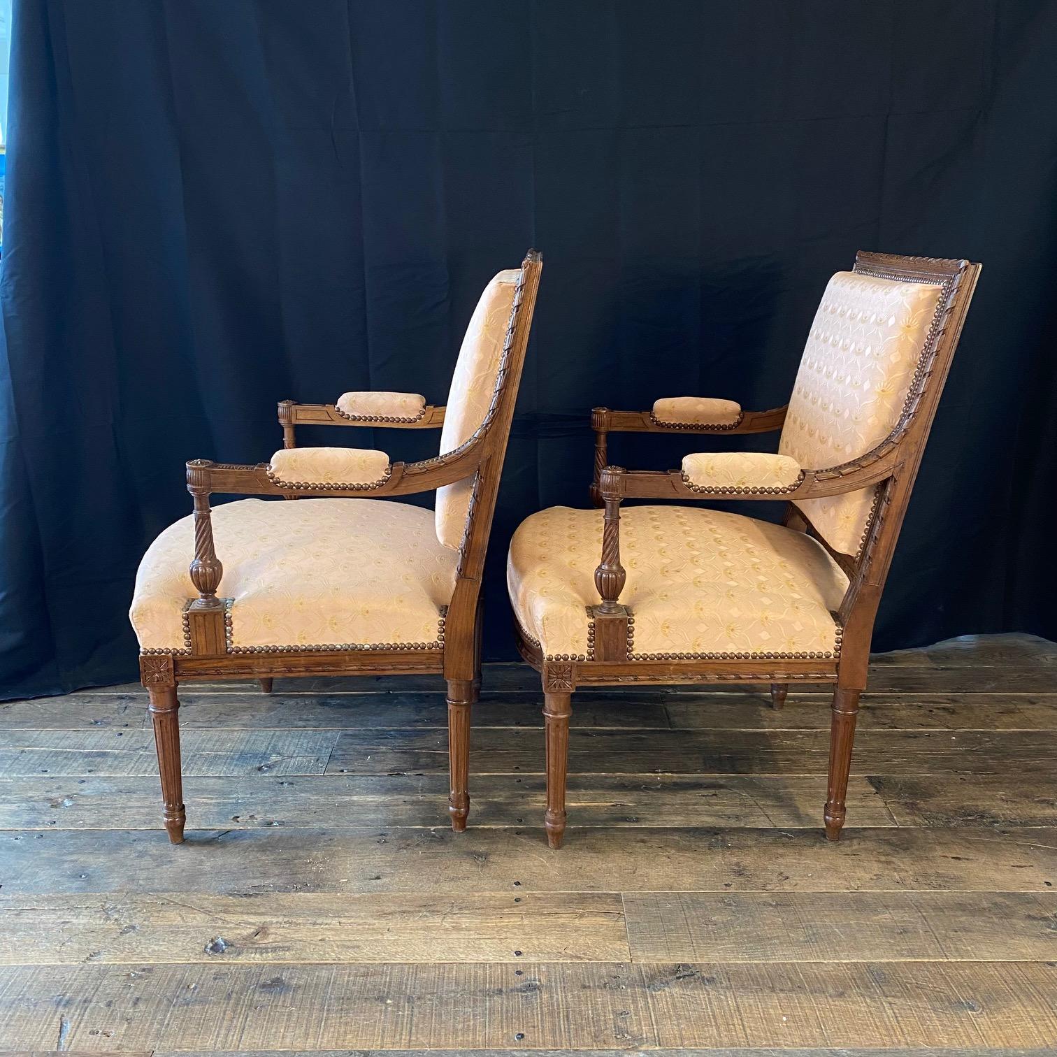 Exquisite Paar späten neunzehnten frühen 20. Jahrhundert Französisch Louis XVI-Stil Sessel oder fauteuils, aus massivem Nussbaum gebaut, mit wunderschön handgeschnitzten Details, einschließlich der schönen Creme und blass rosa Seide Polsterung,