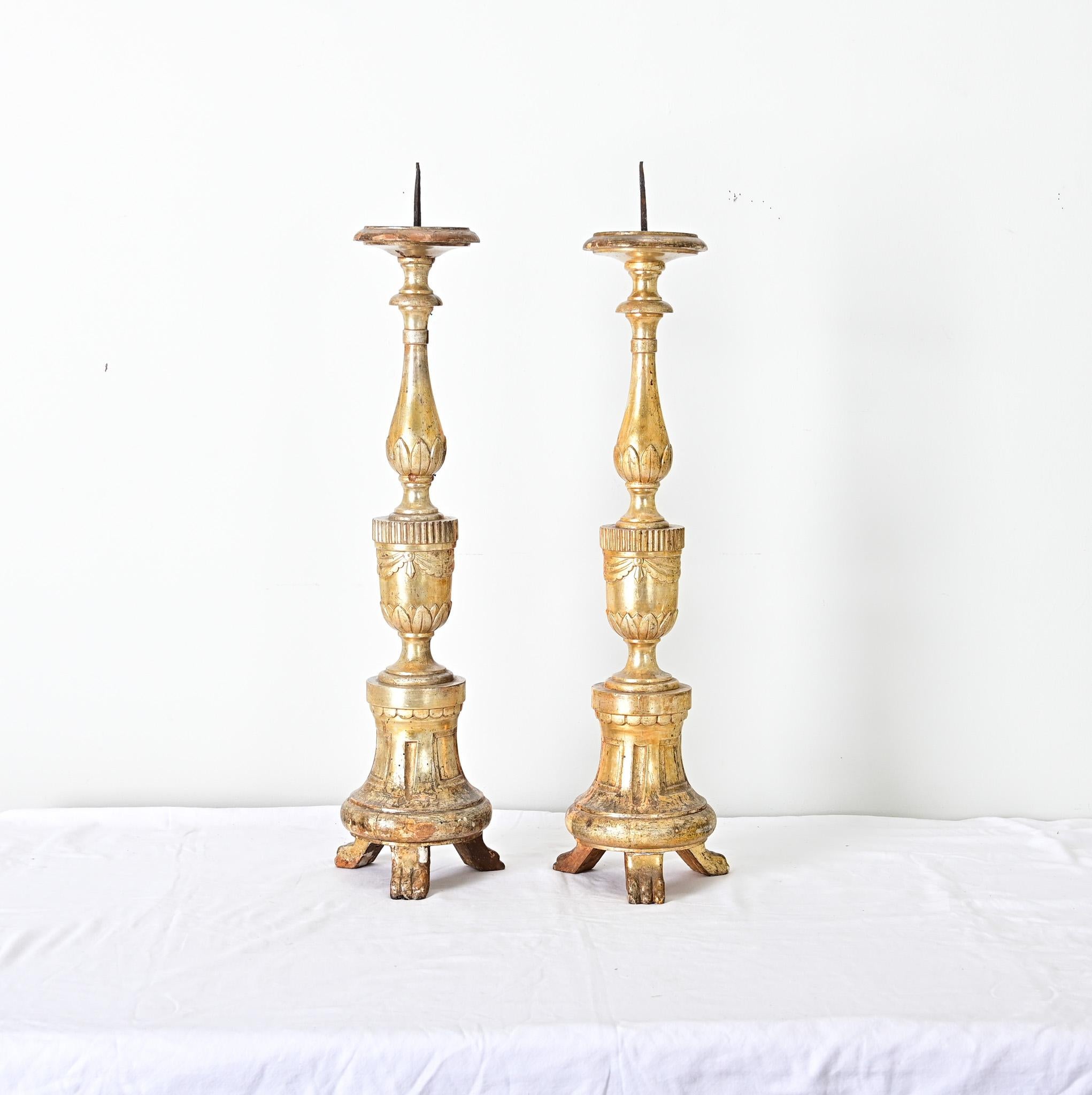 A stunning pair of French, 18th century giltwood candlesticks from a church or cathedral. These substantial “pricket” candlesticks will make a statement on any mantel or table: tall, slender forms on tripod bases are mounted with their original