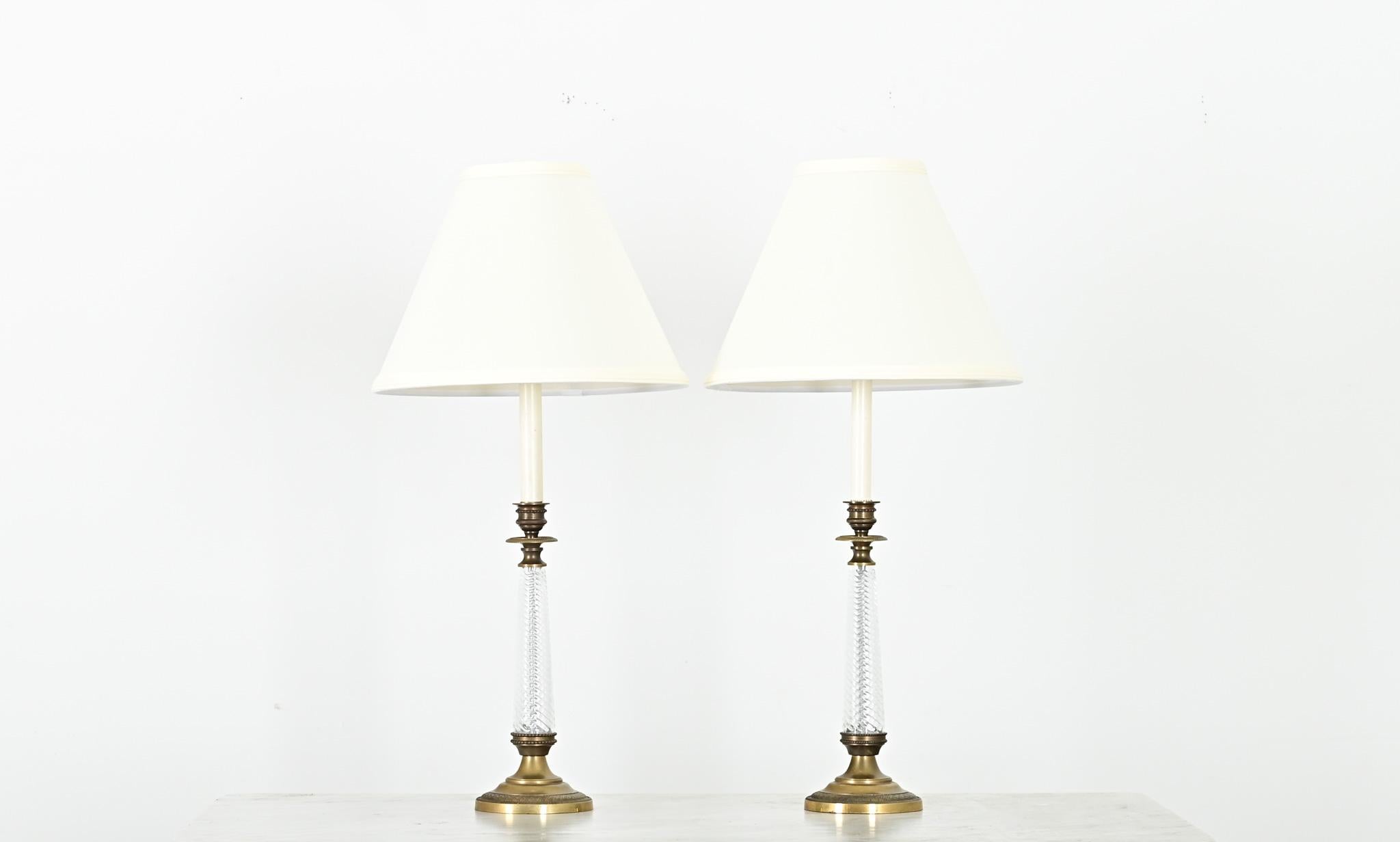 Un deslumbrante par de candelabros de estilo Imperio francés del siglo XIX que han sido convertidos recientemente en lámparas de mesa. Las preciosas bases de las lámparas presentan columnas de cristal retorcidas en el centro (al estilo de la