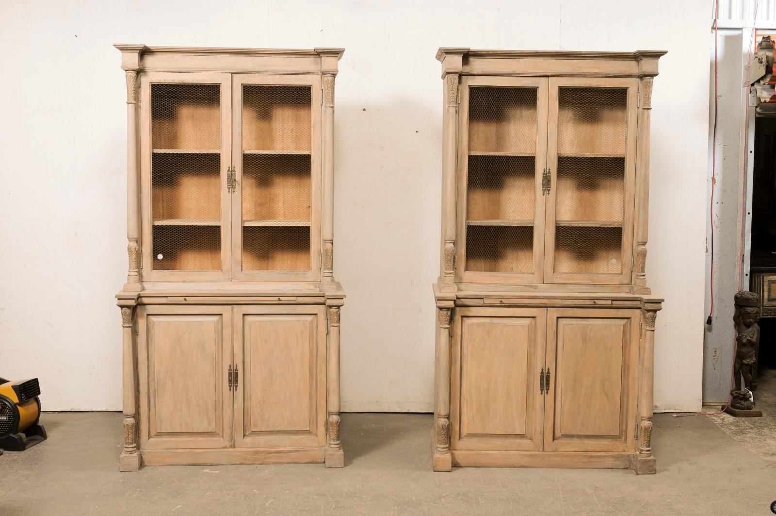 Una coppia di armadi alti francesi, con colonne ben intagliate e ante a filo, della metà del XX secolo. Queste antiche credenze provenienti dalla Francia, ognuna alta poco più di un metro e mezzo, spesso chiamate buffet à deux-corps (che è il nome