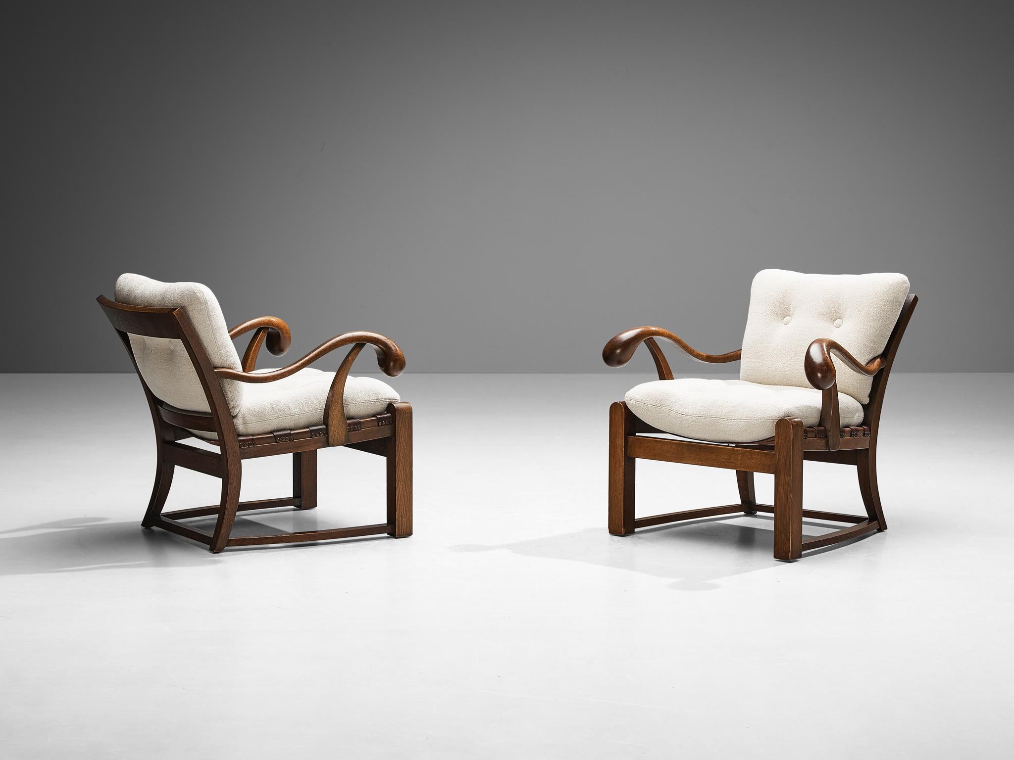 Pair of lounge chairs, oak, reupholstered in Pierre Frey wool, leather, brass, France, 1940s

These beautifully designed armchairs of French origin hold a striking construction by means of the sculpted elements discernible in the wooden frame. The