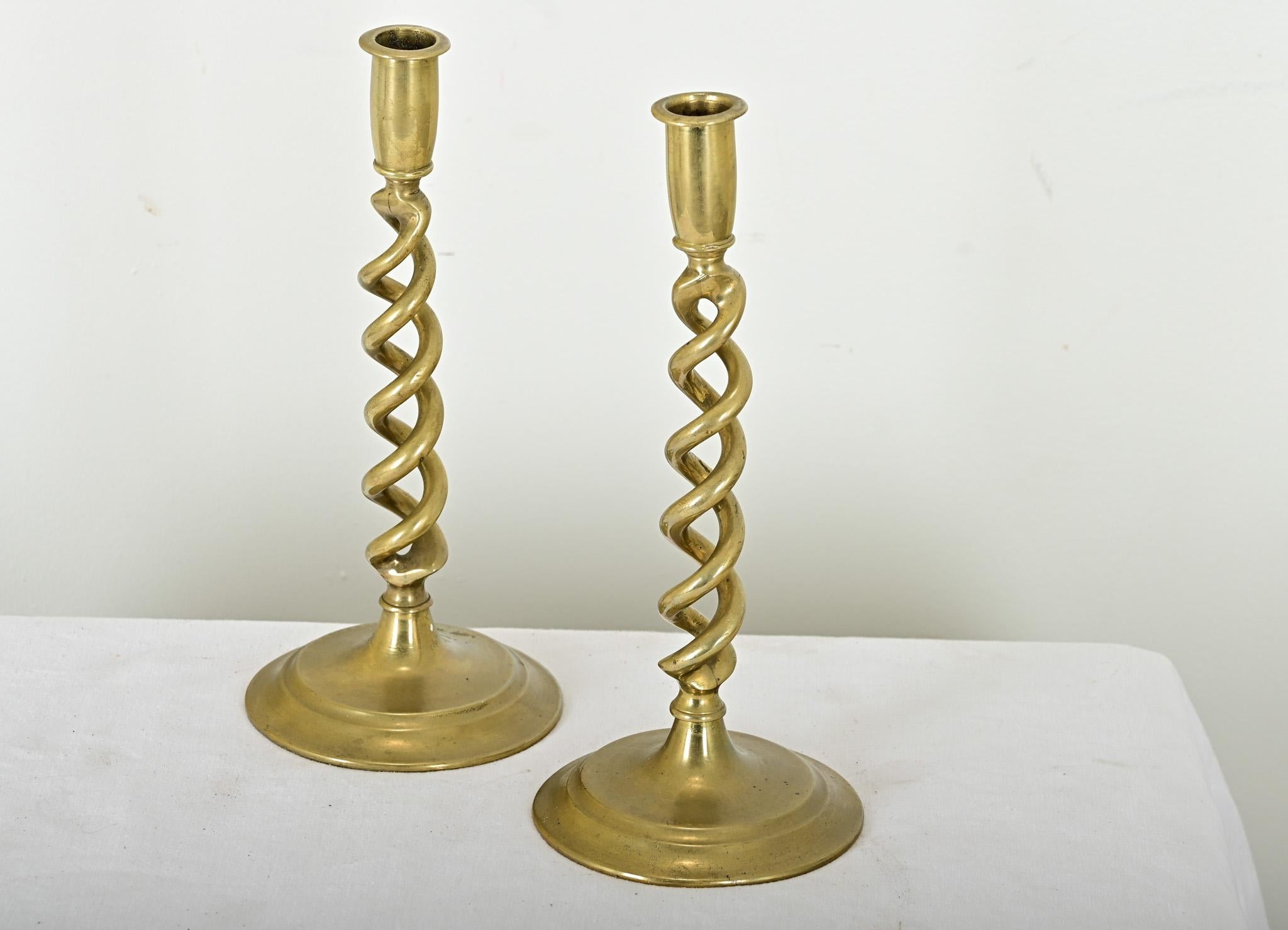 A delightful pair of brass open barley twist candlesticks, hand crafted in France, from the late 19th century. Quite heavy and of fantastic quality regardless of the expected patina, this pair of candlestick holders will add interest to any table or