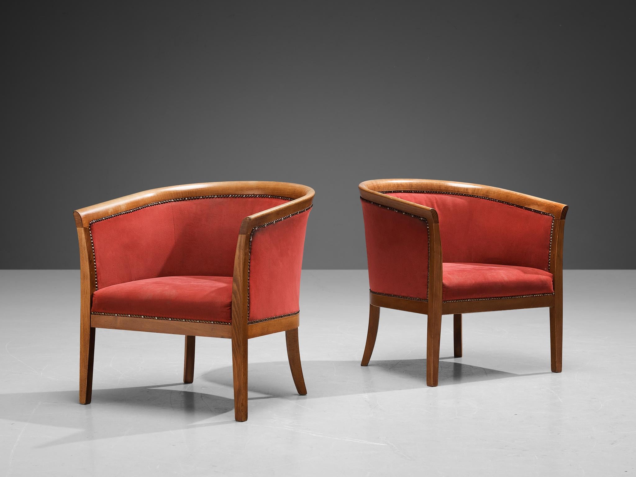 Pair of club chairs, red fabric beech, brass, France, 1940s.

These classically sculpted armchairs feature seatings that are designed as a shell, which embraces the sitter wonderfully. The curvaceous lines of the frame are further emphasized by