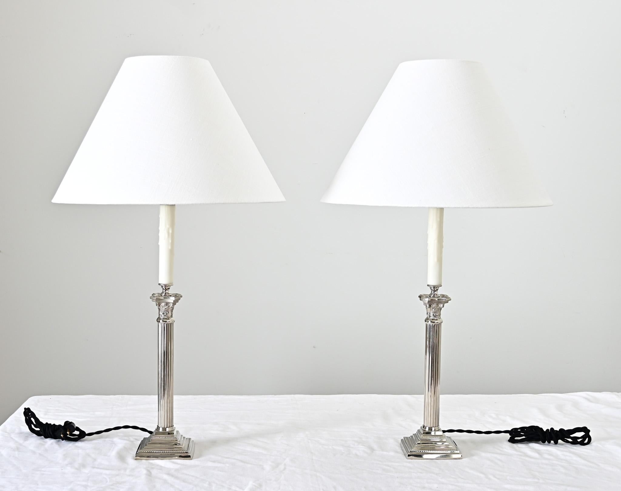 Polished in taste and patina, these vintage French Neoclassical-theme table lamps are a fantastic choice for buffet lighting, side tables, or bedside lamps. The silver metal lamps are fashioned  like miniature Corinthian columns: fluted on the