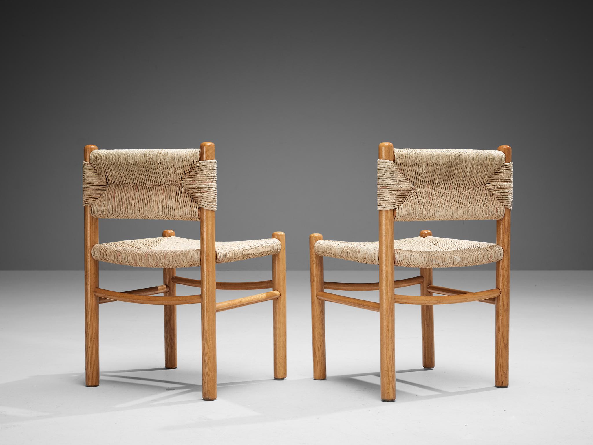 Pair of dining chairs, straw, ash, France, 1960s

This pair of side chairs features a solid wooden frame, consisting of cylindrical thick legs that are connected to each other with elegant slim horizontal slats. The seats and backrests are executed