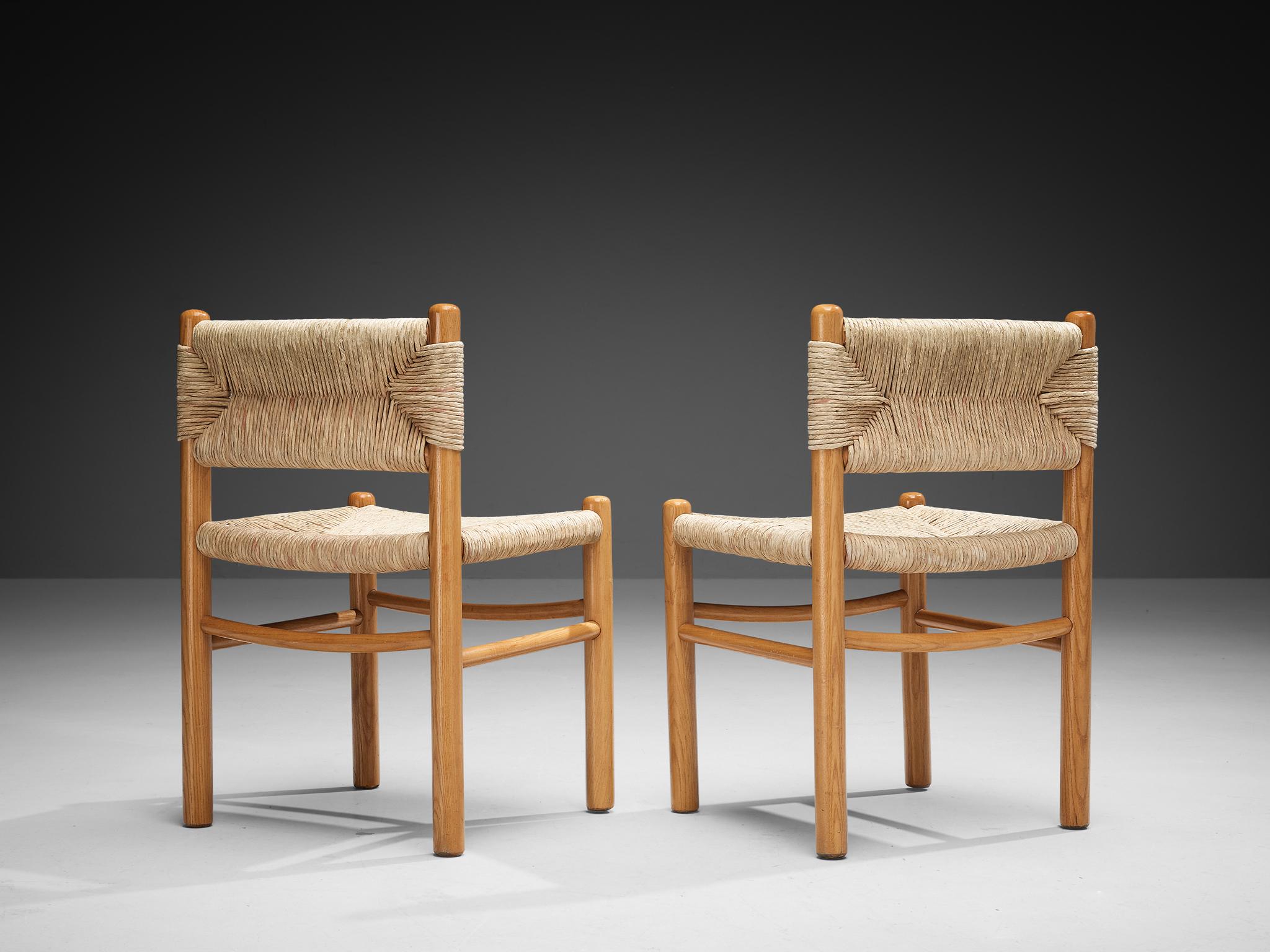 Paire de chaises de salle à manger, paille, frêne, France, années 1960

Cette paire de chaises d'appoint présente un cadre en bois massif avec de robustes pieds cylindriques, élégamment reliés par de minces brancards horizontaux. Les assises et les