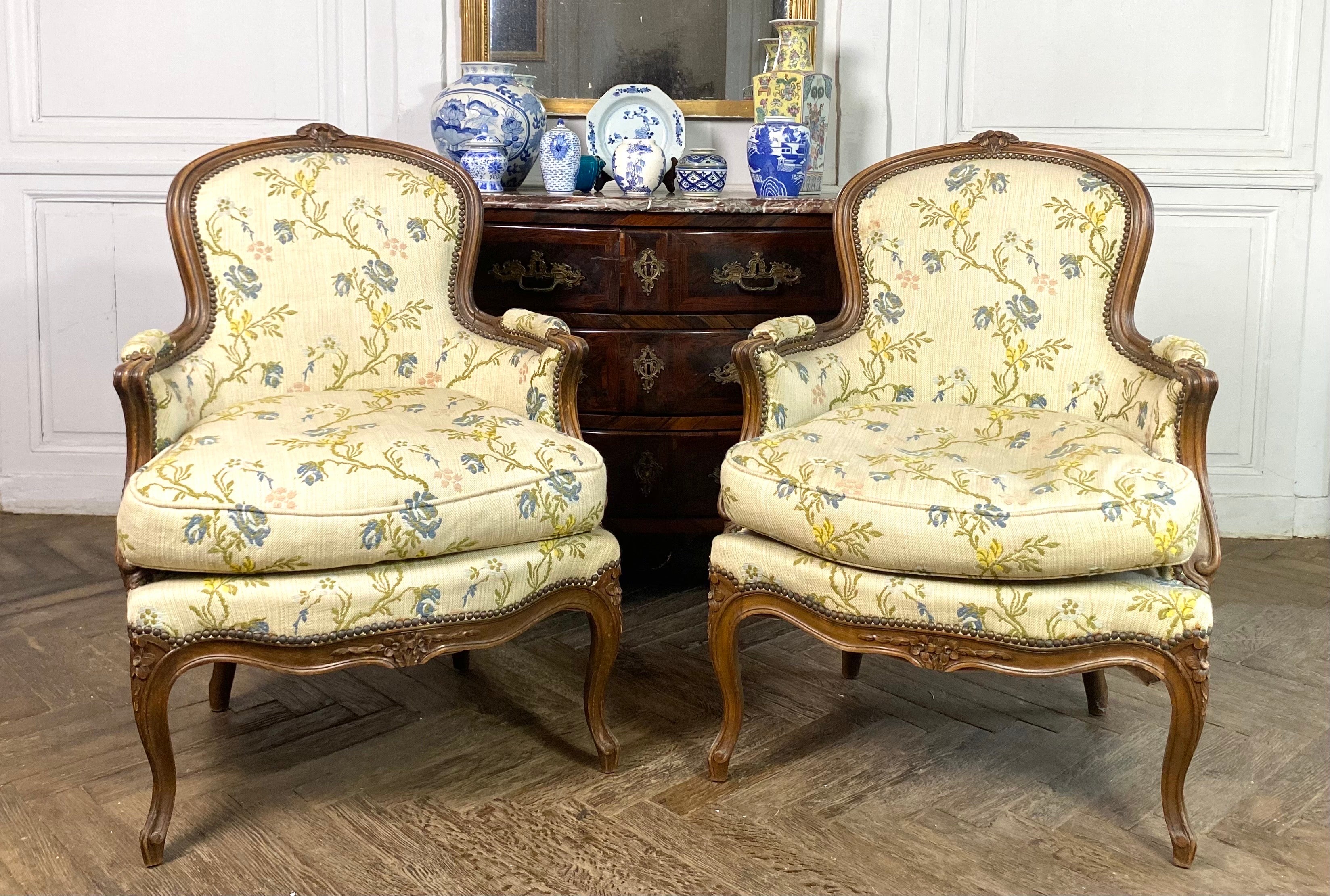 Wonderful pair of Louis XV style shepherd armchairs from the XIXth Century in carved wood. With vegetable decoration of flowers carved on the convertible backrest and on the deeply molded moving belt.
The whiplash armrests have cuffs.
The armchairs
