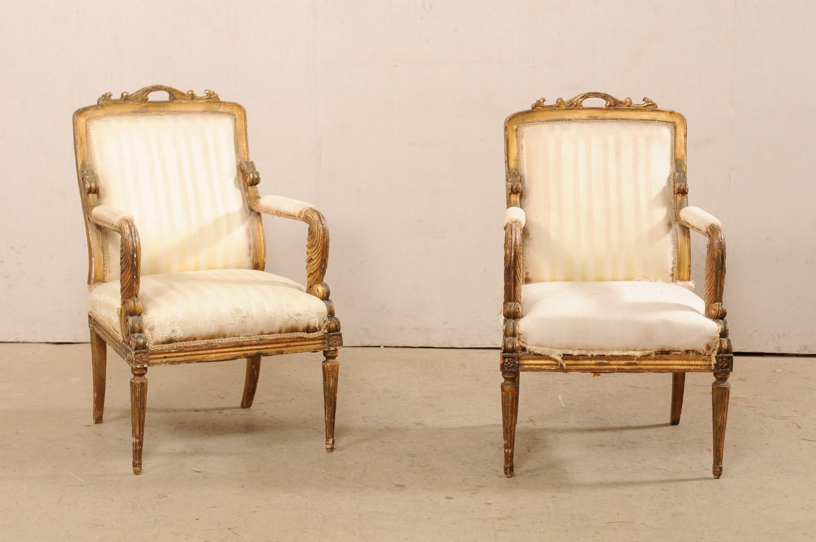 A French pair of Louis XVI style, carved-wood fauteuil armchairs from the early 19th century. This antique pair of armchairs from France, are hand-carved in the in the influences of Louis XVI period, each featuring rectangular-backs with a raised