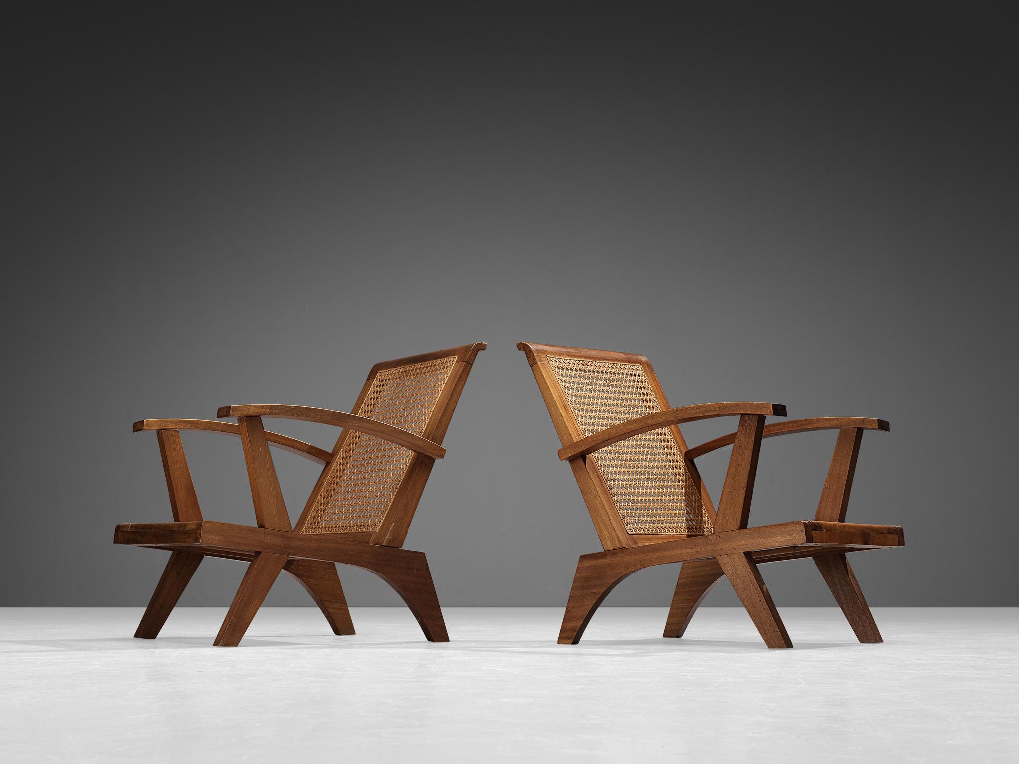 Pair of lounge chairs, cane, teak, France, 1950s 

These armchairs strongly remind of the iconic chairs created by the talented Swiss architect Pierre Jeanneret (1896-1967) who is known for his constructivist approach to furniture design. The design