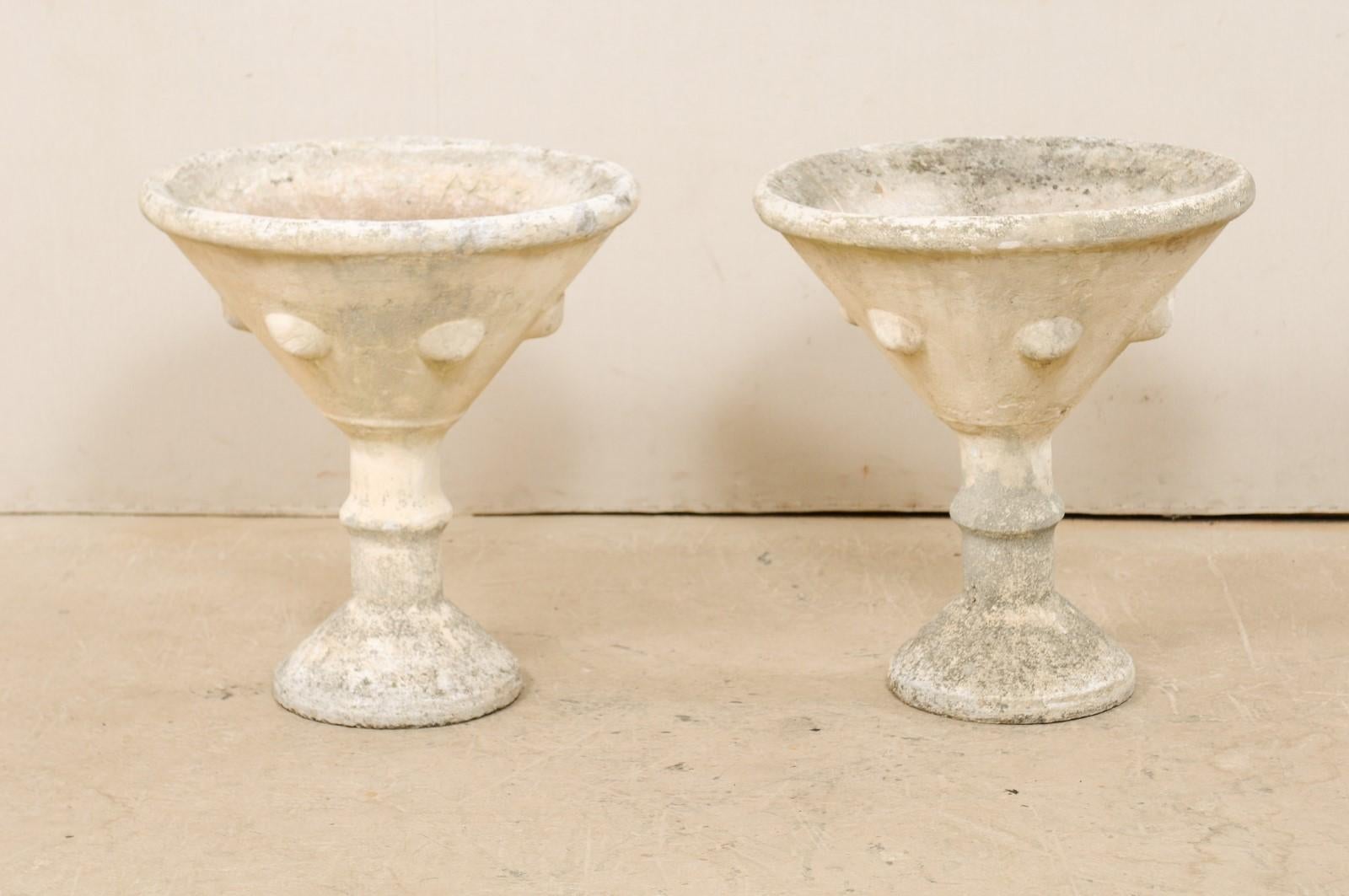 A pair of French tall cast stone outdoor planters from the mid-20th century. This pair of vintage French planters have been made of cast stone and have a playful, 