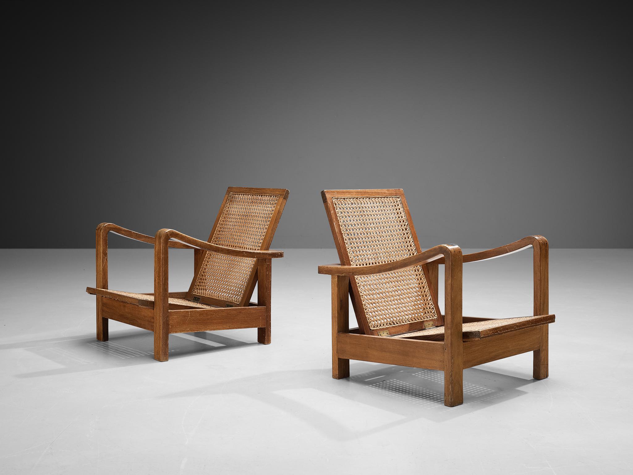 Pair of lounge chairs, oak, cane, France, 1940s/1950s.

A truly lovely pair of armchairs in a natural oak. The seats and backrests are made of cane. The seating part has a sliding mechanism in the frame and can be adjusted for comfort when in use,