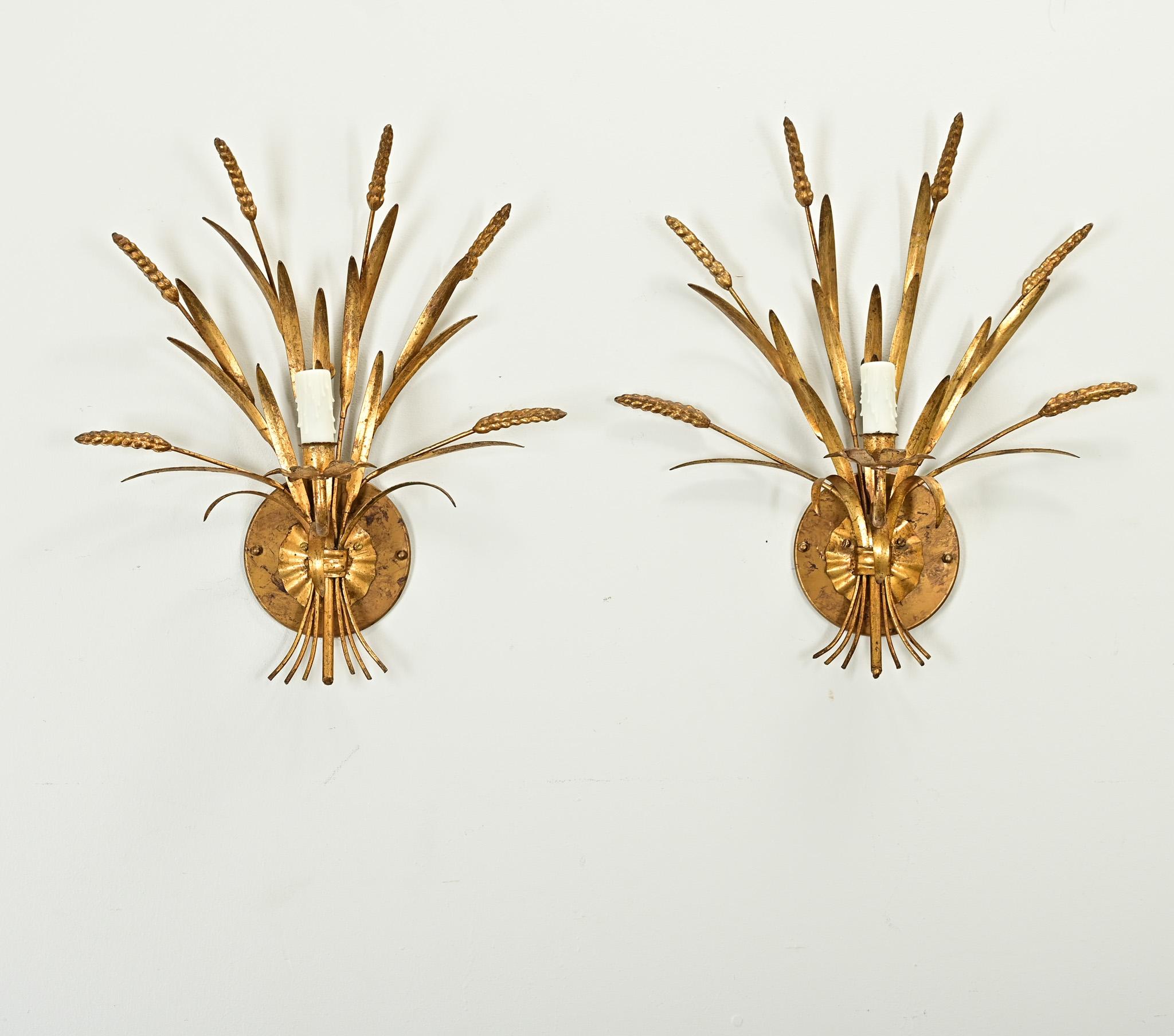 
Questa coppia di applique dorate d'epoca (circa 1970) in stile Hollywood Regency francese utilizza il simbolismo del grano per glorificare l'agricoltura, promuovendo l'abbondanza e la prosperità in ogni stanza in cui vengono appese. Il design è