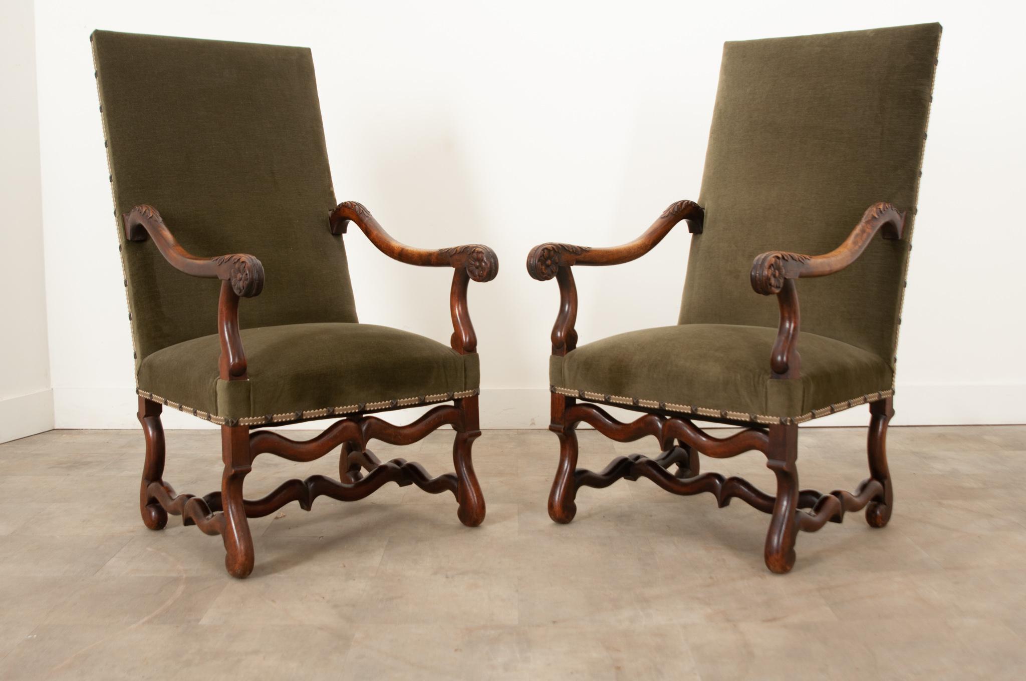 An impressive pair of French Os de Mouton armchairs with wonderfully carved details hand-crafted in France in the 19th century. These large armchairs are very comfortable and covered with new green velvet upholstery, thoughtful grosgrain trim, and