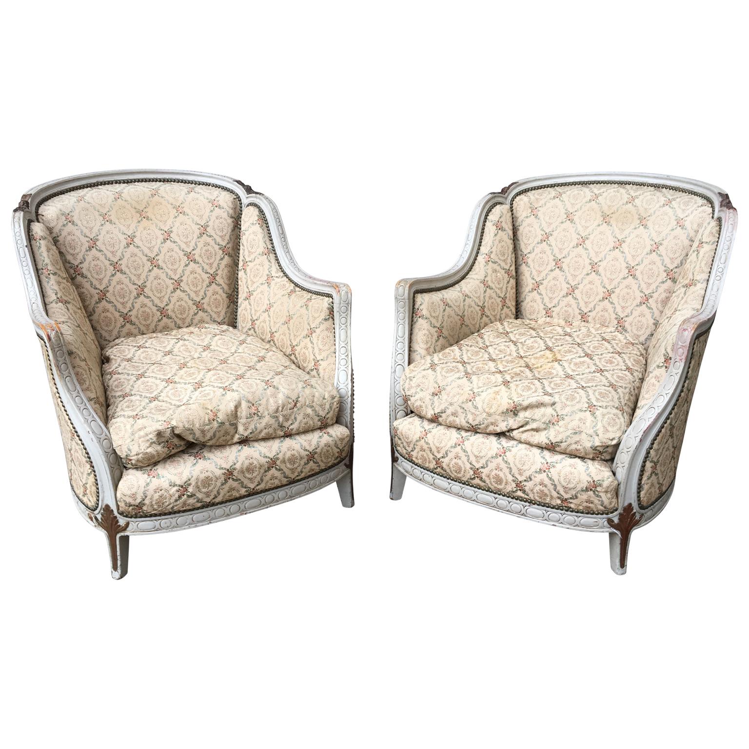 A pair of French bergère armchairs in white painted wooden frame. The original paint is circa 1920-1930. The armchairs are super-sized and a very comfortable size and feel.