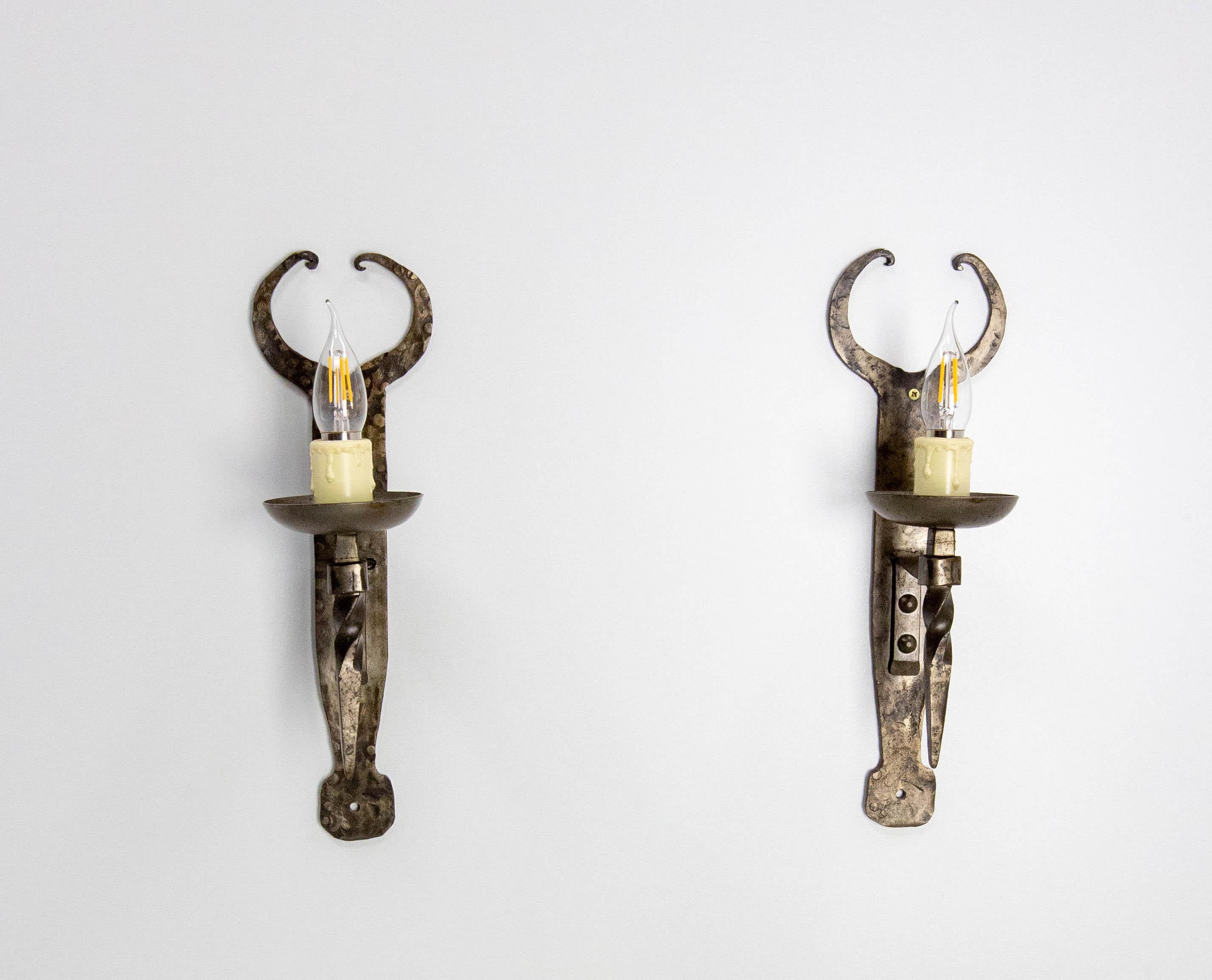 Paire d'appliques du milieu du siècle dernier de fabrication française vers 1960. 
Fer forgé.
Ils sont conformes aux normes des États-Unis et de l'UE ou du Royaume-Uni.
En raison des différences entre les systèmes électriques européens et