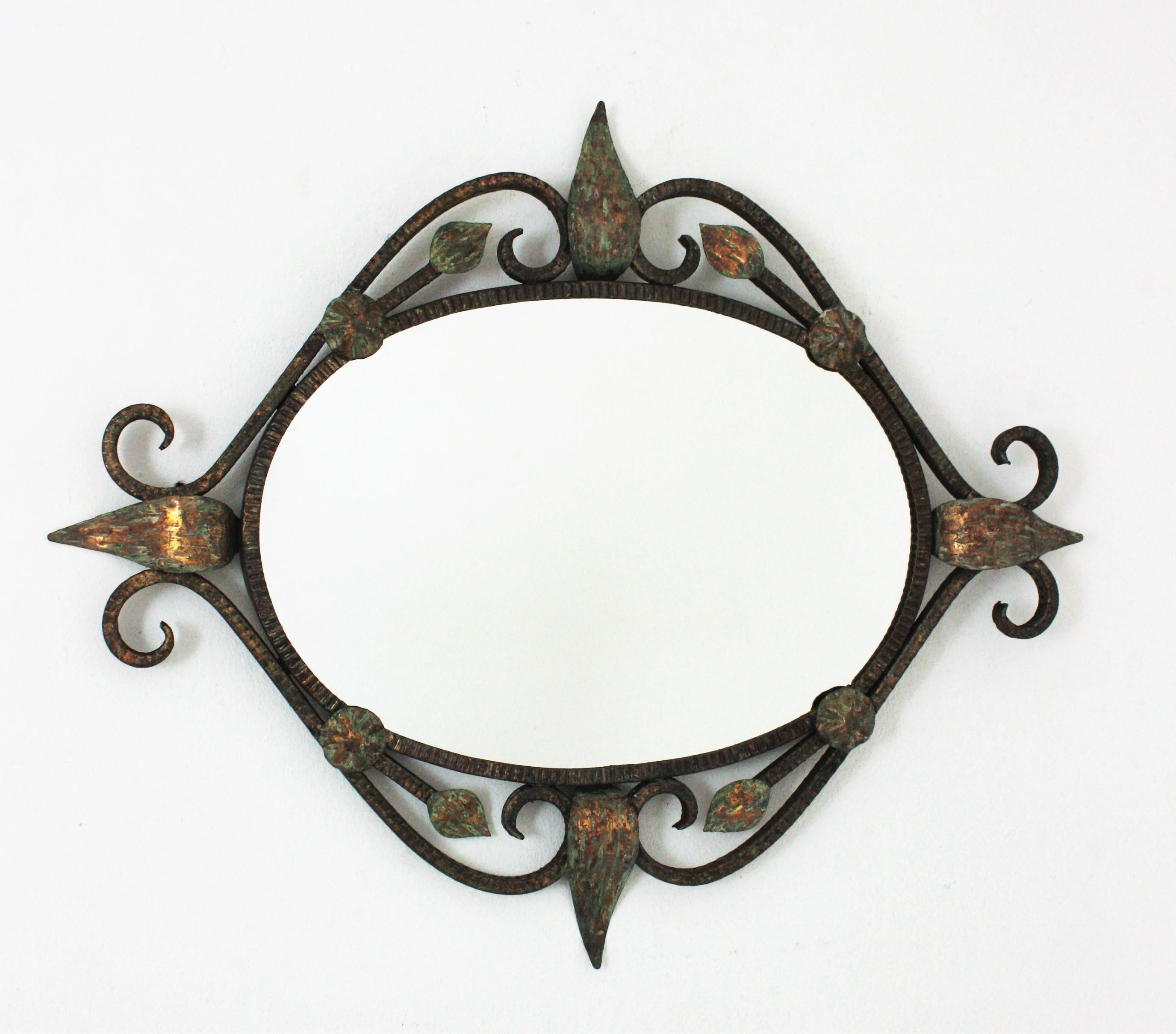 Parcel Gilt wrought iron oval mirror with scroll and leaves details, France, 1940s.
Beautiful design and terrific aged patina showing rests of the orgininal gold leaf gilding with green accents.
Measures: 74 cm H x 60 cm W x 5 cm D 
Glass measures: