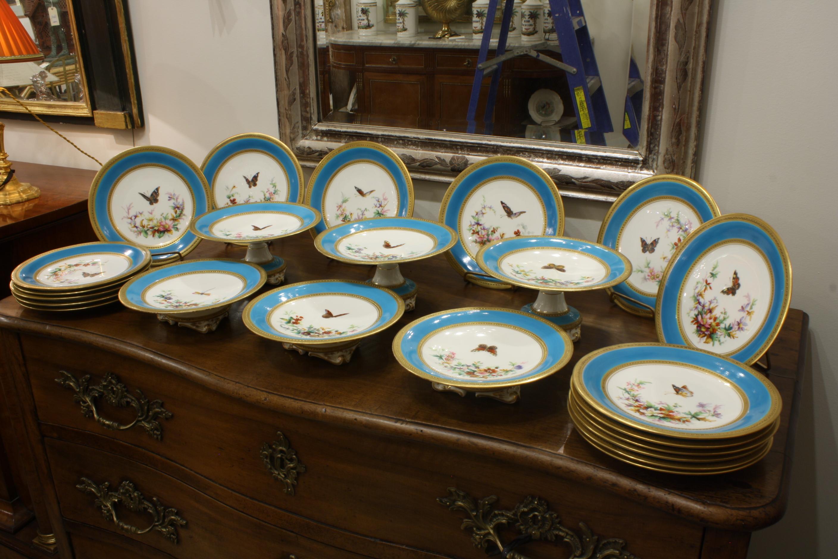 Straordinario servizio da dessert in porcellana attribuito a Minton composto da 23 pezzi con fondo turchese, farfalle dipinte a mano, fiori e ghirlande floreali. I perimetri e i diametri interni dei piatti sono perlinati e dorati. Il servizio
