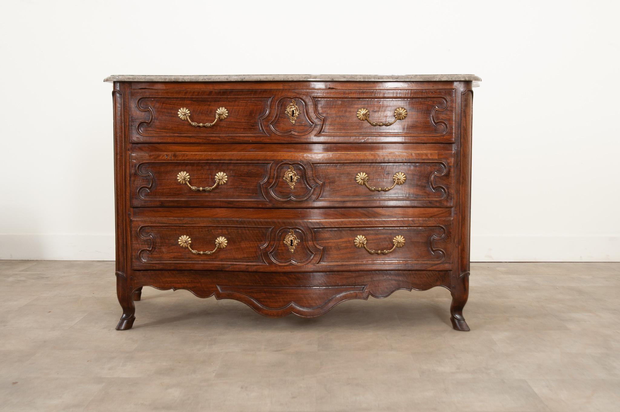 This fantastic Parisian solid rosewood and walnut commode was crafted in 18th century France circa 1740.  In great antique condition- the original marble top with a modeled edge is shaped according to the body of the piece. The rosewood and walnut