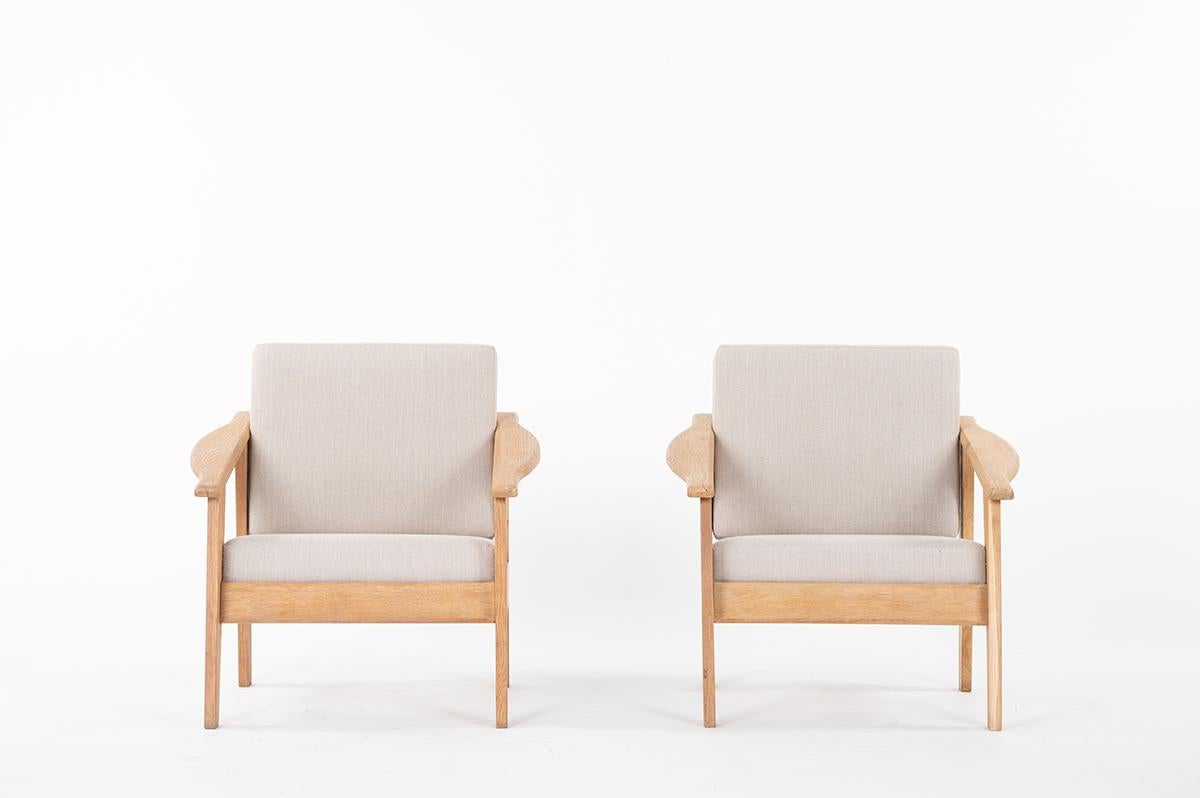 Set of 2 armchairs designed and produced in 1950 for a Parisian appartment. 
Composed of solid oak brushed structure, foam seat and back cushions cover in French natural linen. 
Minimalist and modernist shapes.