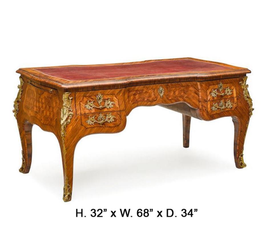 Exquisite and Rare French Louis XV style gilt bronze mounted parquetry partner desk, 19th century.
The red leather writing surface is inset into a shaped moulded top, above a parquetry decorated frieze fitted with three drawers and two sham drawers