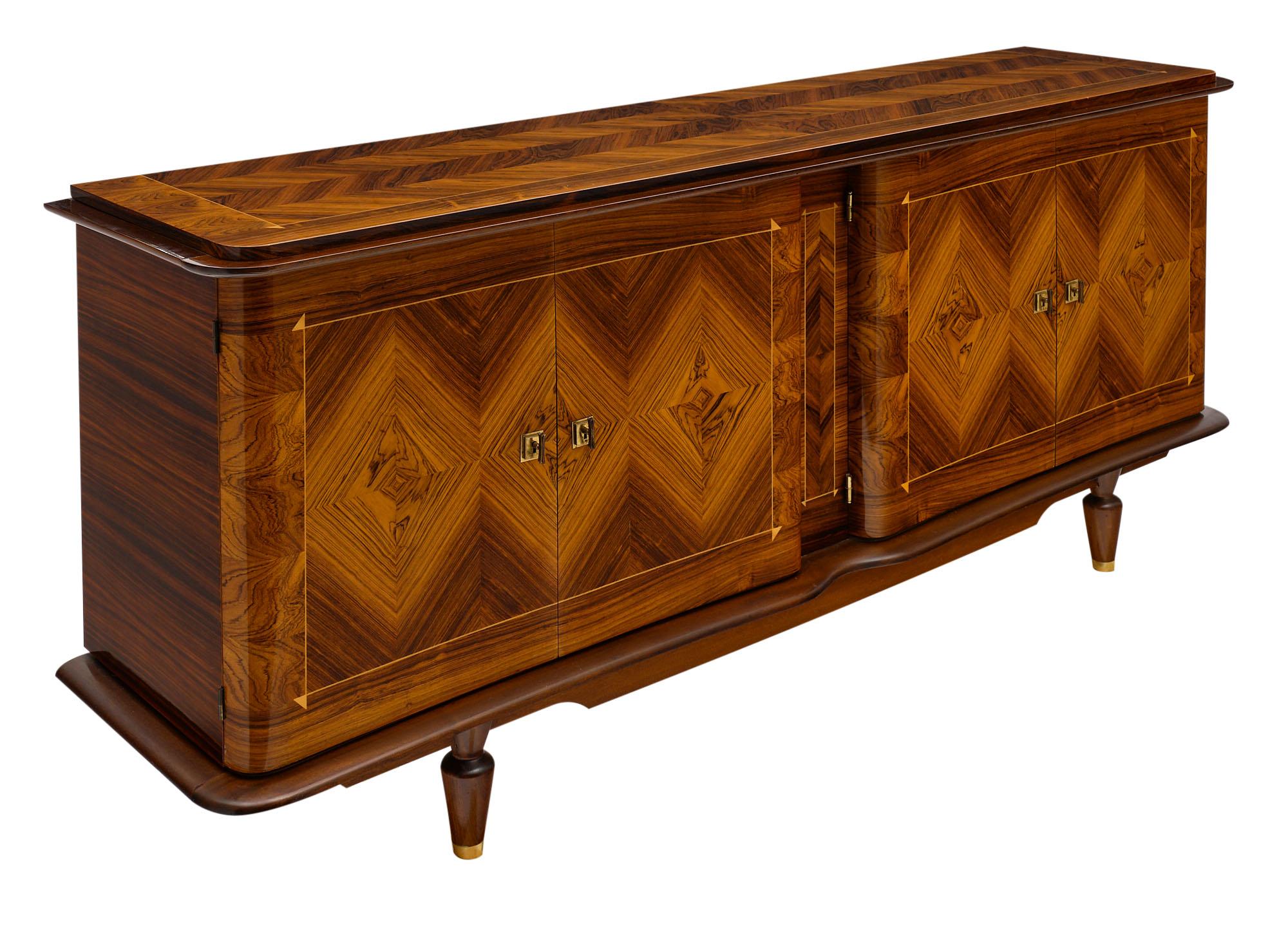 Buffet from France made of rosewood; tinted rosewood; and burled walnut. The important sideboard features an elaborate work of parquetry on its top; sides; and facade where four doors open up to an array of shelves and drawers within. This piece is