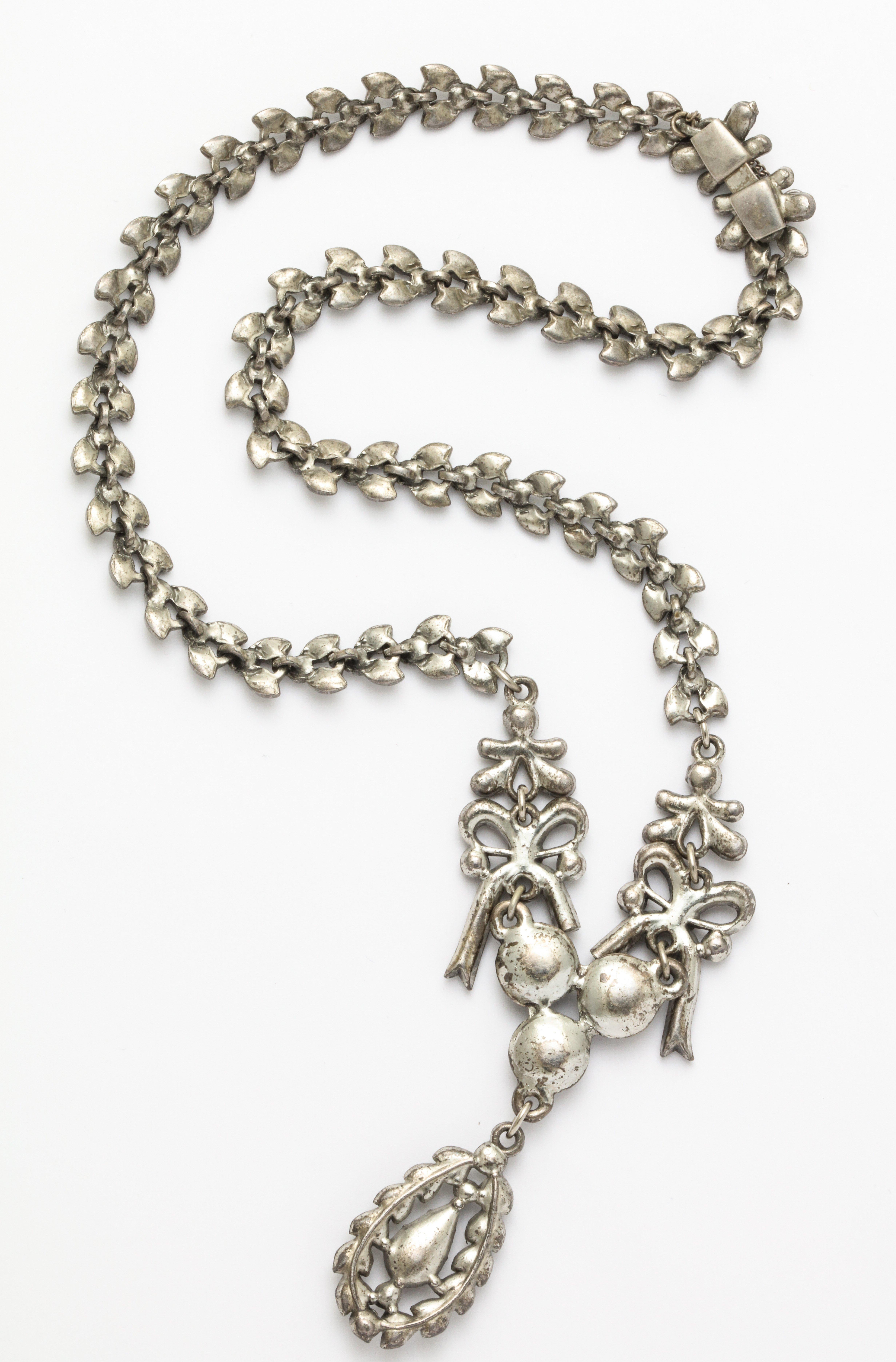 This early French Paste necklace has a lovely design with bows either side of an intricately set collier a center pendant 