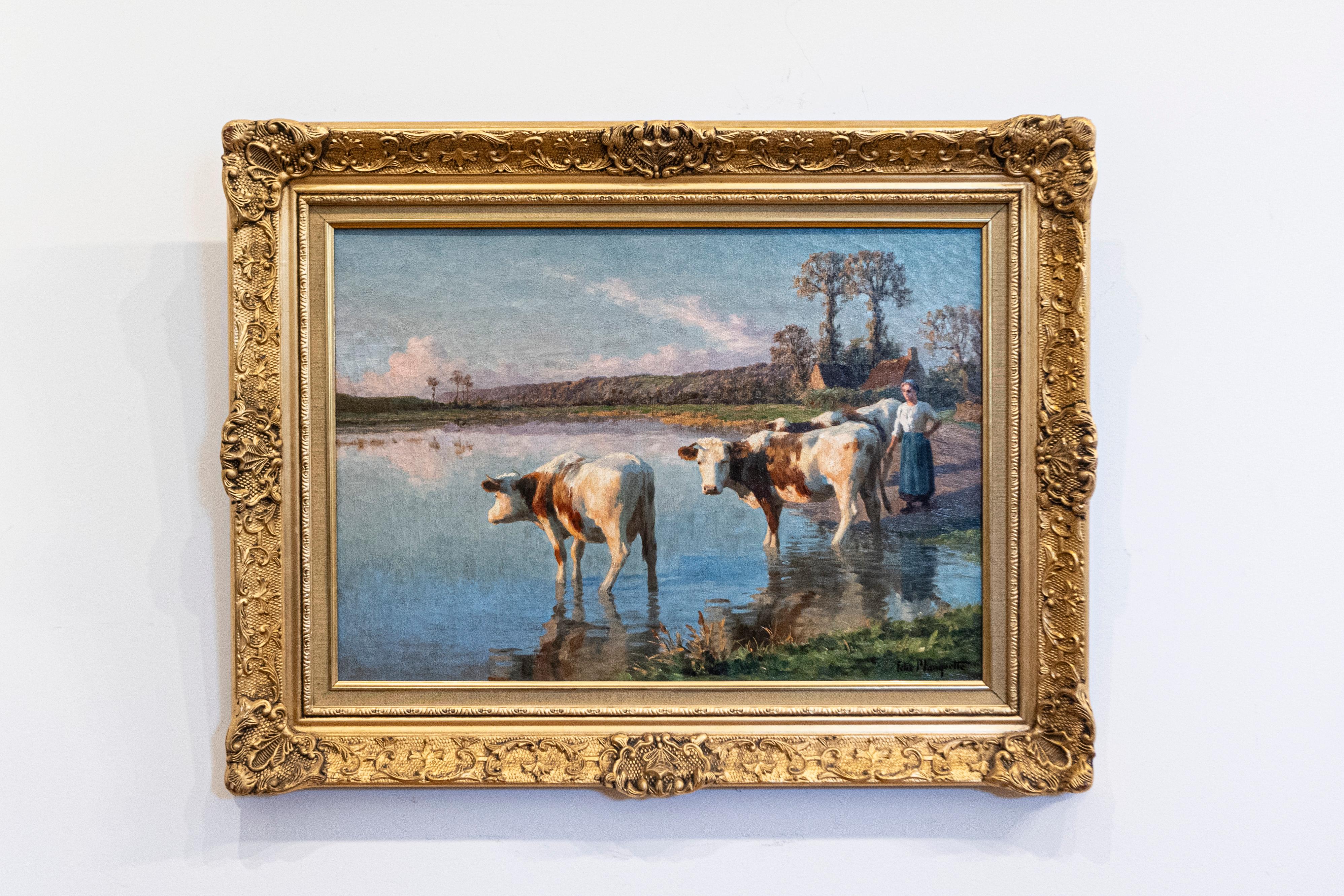 Peinture à l'huile pastorale française de la fin du XIXe siècle par Félix Planquette (1873-1964), représentant une paysanne avec ses vaches au bord d'une rivière, dans un cadre en bois doré. Cette exquise peinture française présente une scène