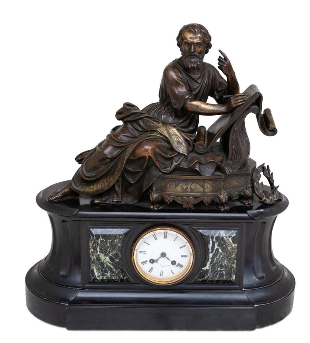 Französische Figurenuhr aus patinierter Bronze und Marmor, spätes 19. Jahrhundert, abgerundete rechteckige Form, bekrönt von der Figur eines liegenden Philosophen, darunter eine Tafel mit der Inschrift 
