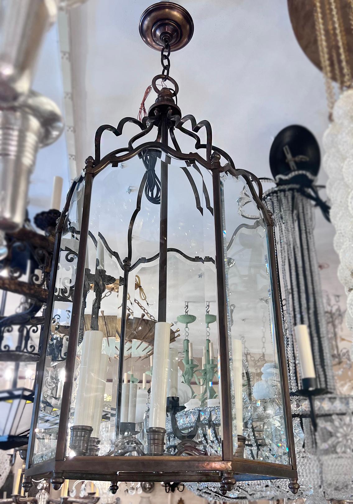 A French neoclassic style patinated bronze lantern with glass panels and circa 1920s six interior candelabra lights.

Measurements:
Present drop 42