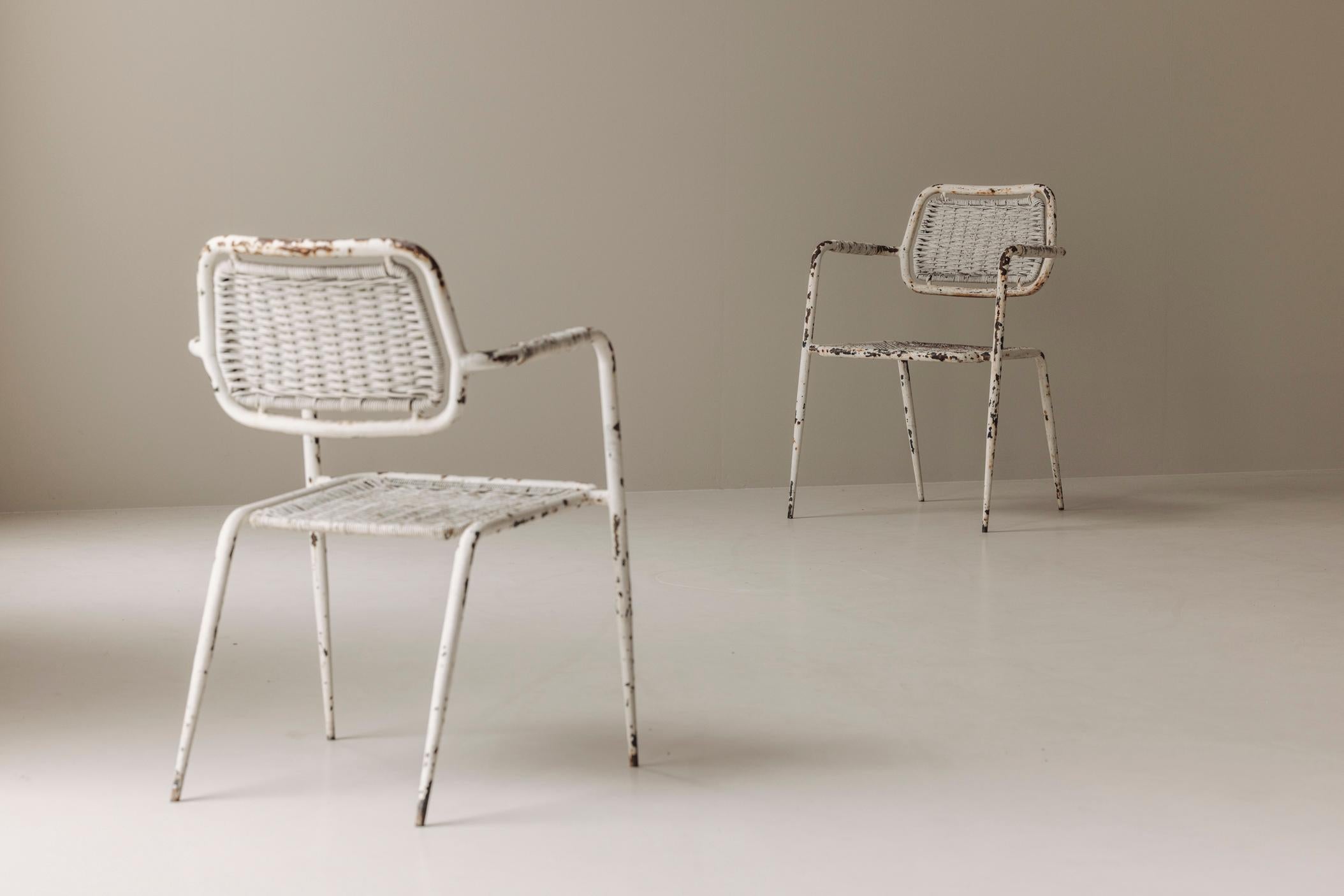Raw, honest, and full of charm—this rare pair of 1950s French industrial armchairs brings the soul of the workshop into the refined interior. With tubular metal frames and woven synthetic wicker seats and backs, these chairs embody utilitarian