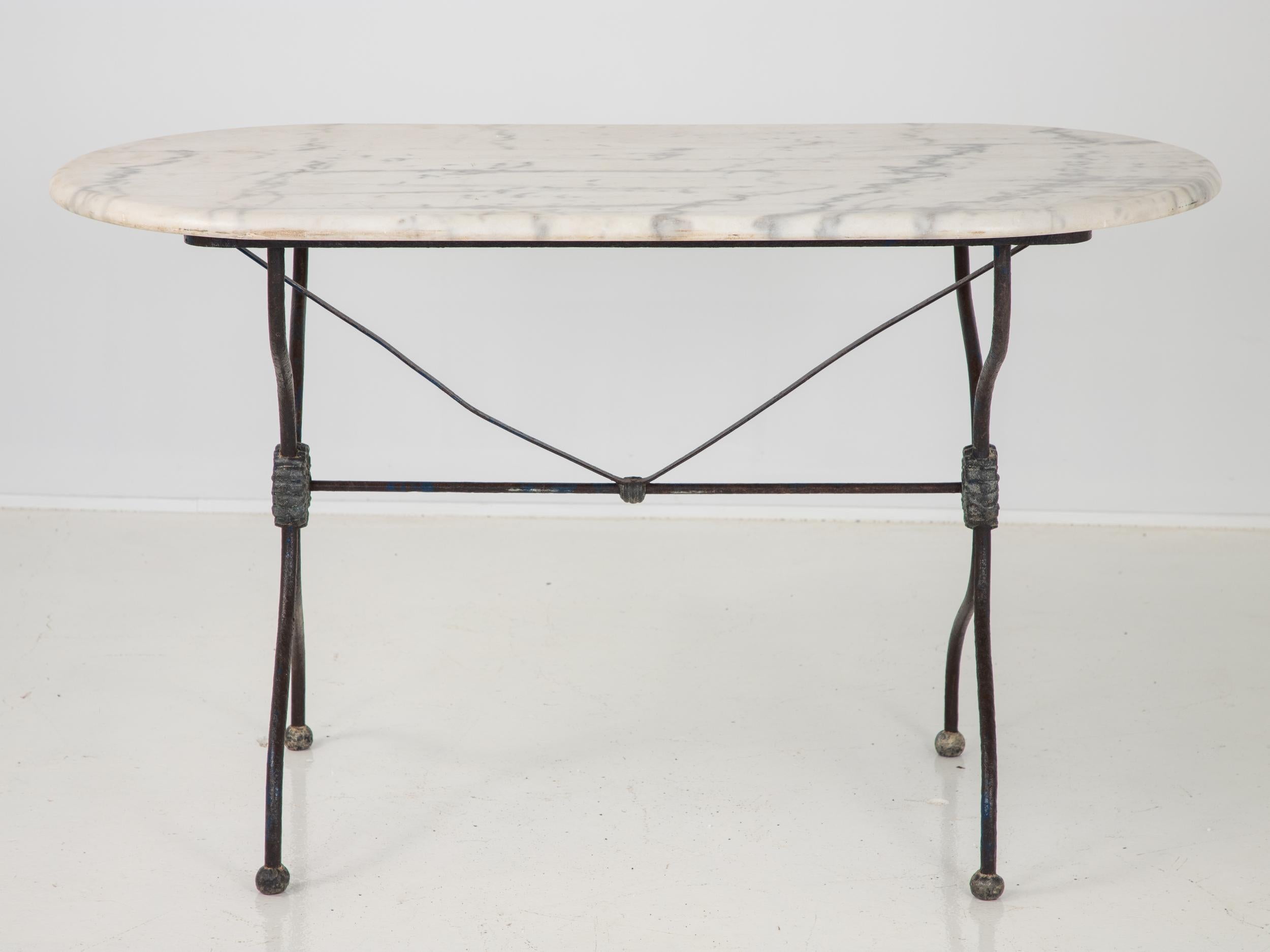 French patisserie table with original white marble top. A sturdy iron base in the classic French style. White marble in an unusual rounded shape.