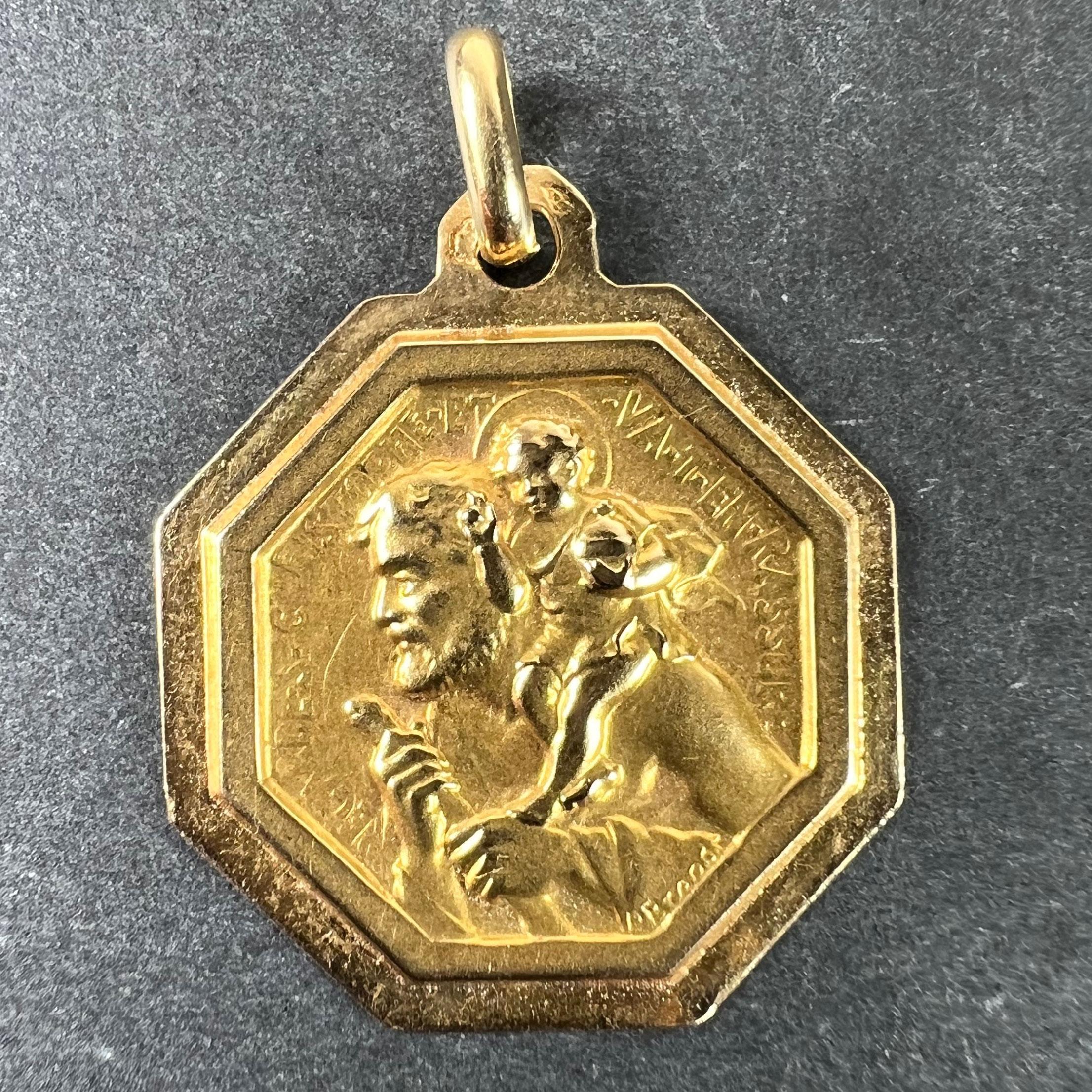 Pendentif à breloque ou médaille octogonale en or jaune français 18 carats (18K), conçu par Paul Brandt, représentant saint Christophe portant l'enfant Christ à travers la rivière. Les personnages sont entourés de la phrase 