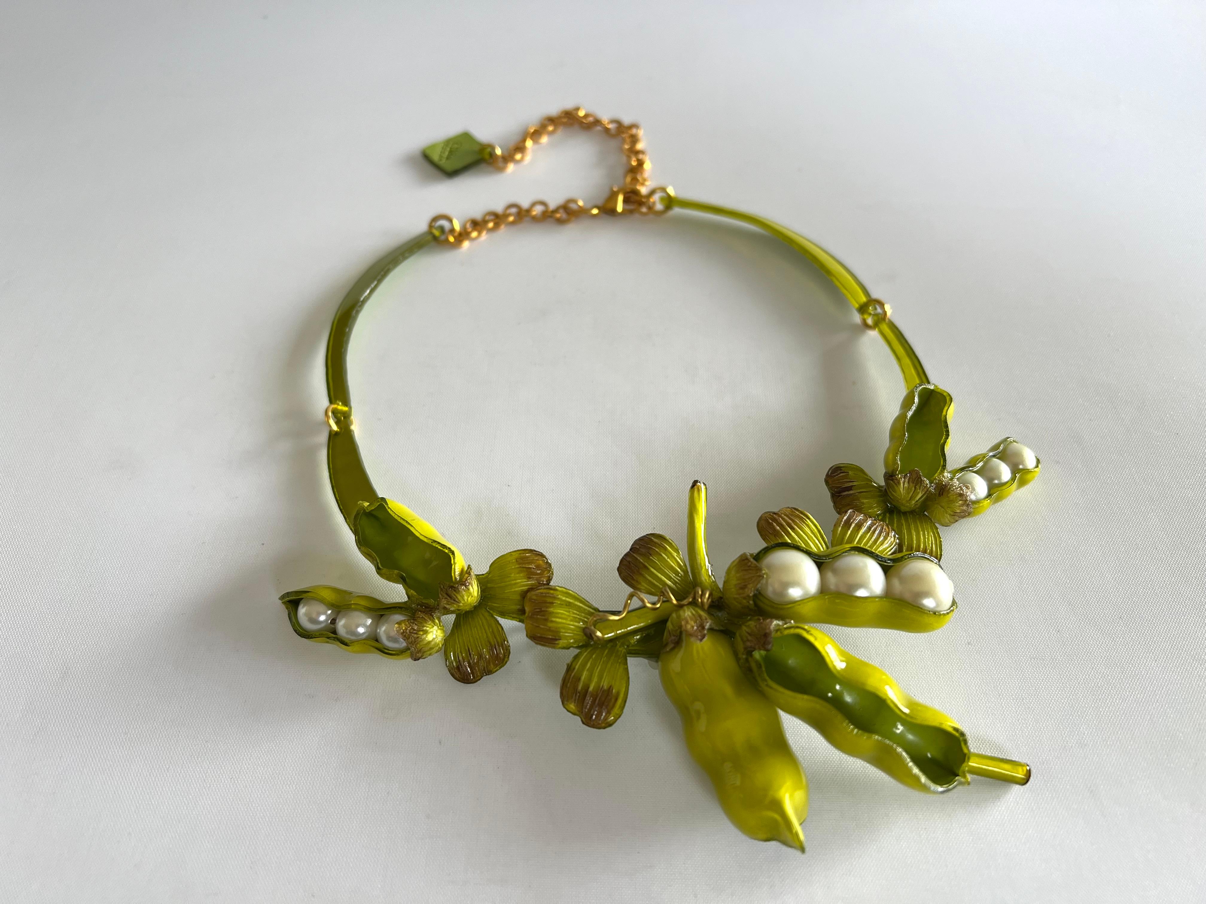 Light and easy to wear, this handmade artisanal necklace was made in Paris by Cilea. The necklace features three whimsical peas in a pod of enameline (enamel and resin composite) with faux pearl center details. A unique, well-crafted statement