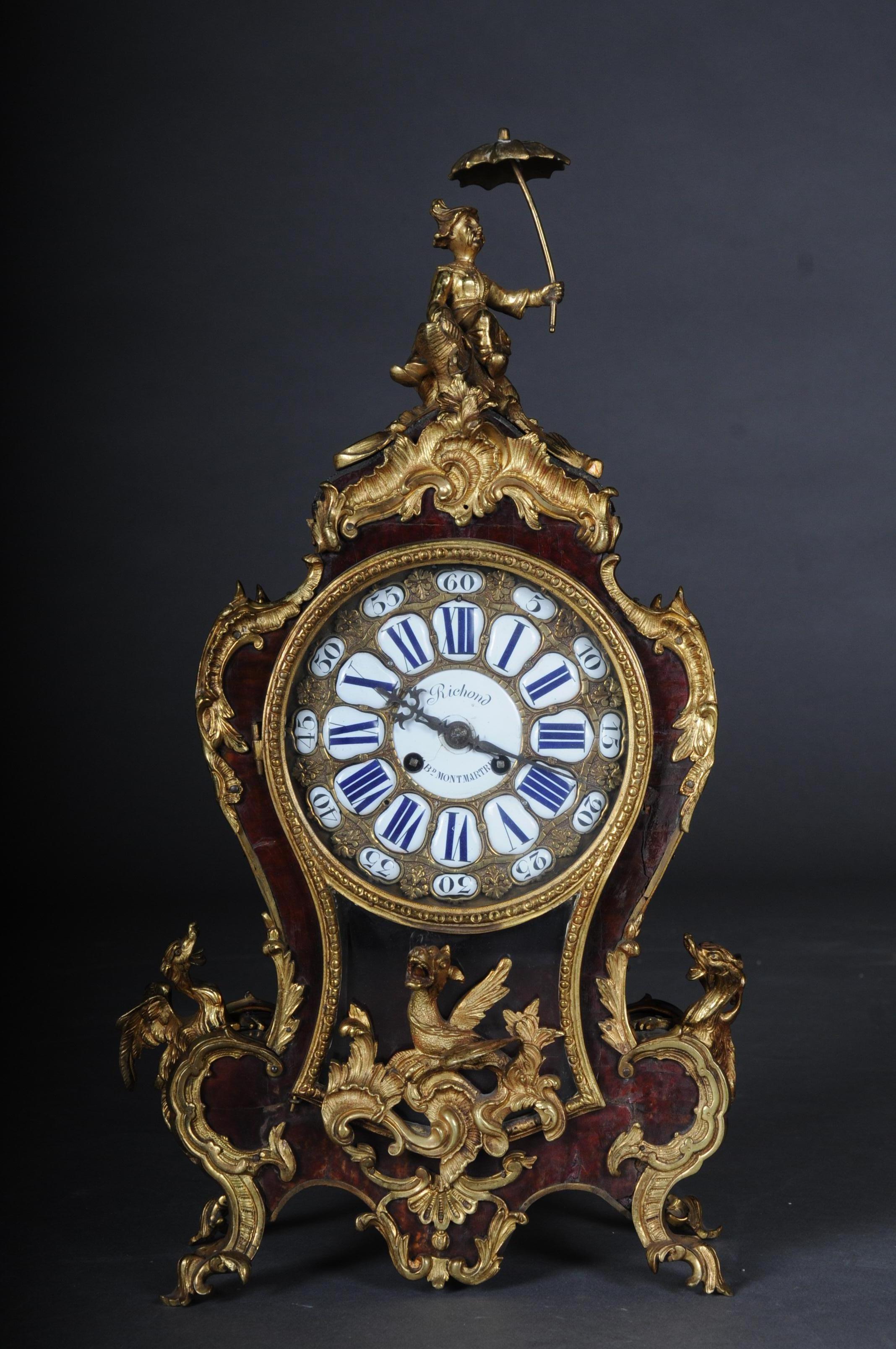 French pendulum clock / mantel clock, Boulle style Paris, circa 1870.

Paris, circa 1880
The waisted case, veneered with red tortoiseshell and grilled on the sides, rests on four leaf feet. Gilded bronze appliqués. Dragons sitting on the side and