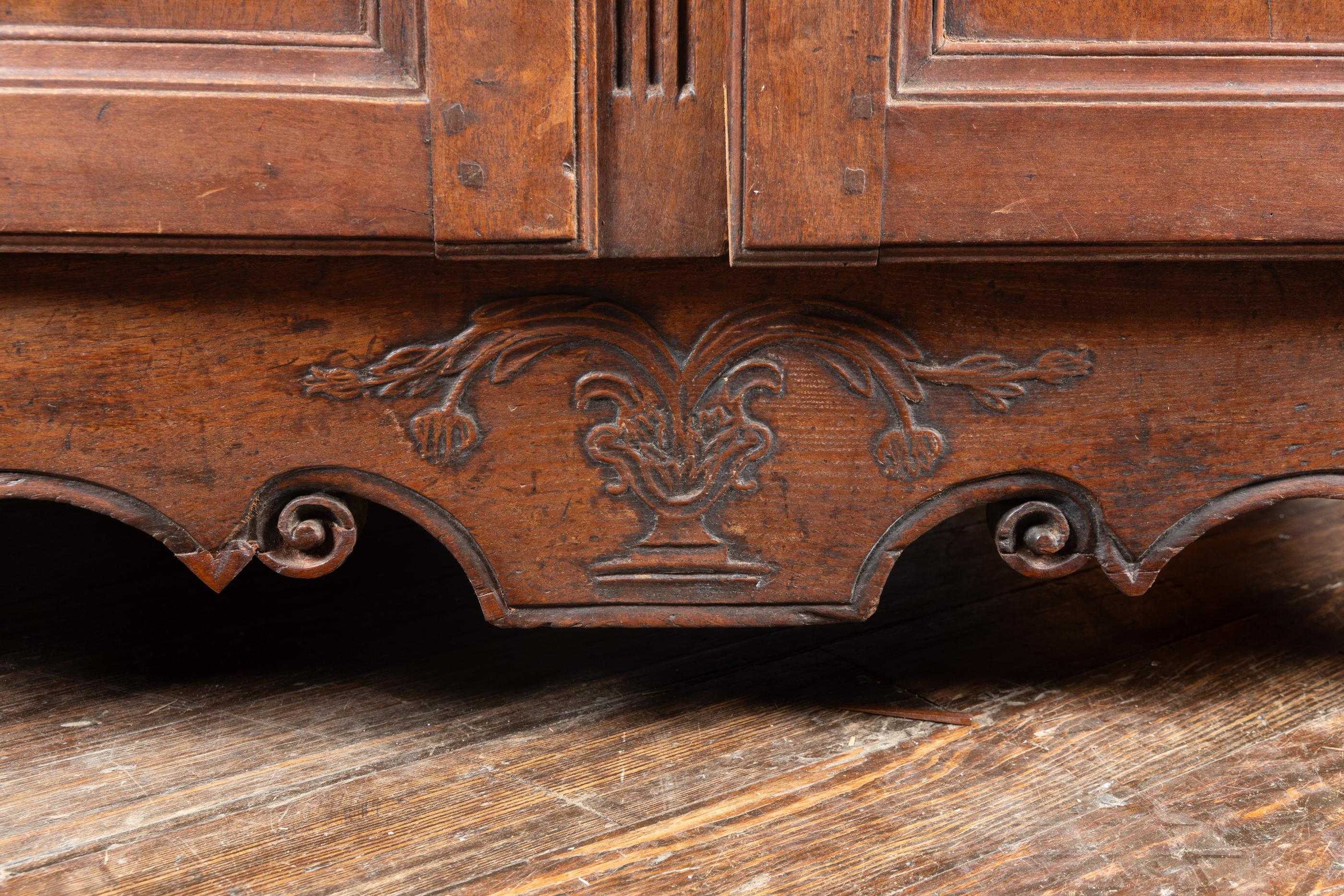 Magnifico buffet in noce intagliato di epoca francese del XVIII secolo Luigi XV, proveniente dalla Normandia, caratterizzato da un cesto floreale intagliato al centro del grembiule, da cerniere e da rosette in bronzo cesellato a mano e poggiante su