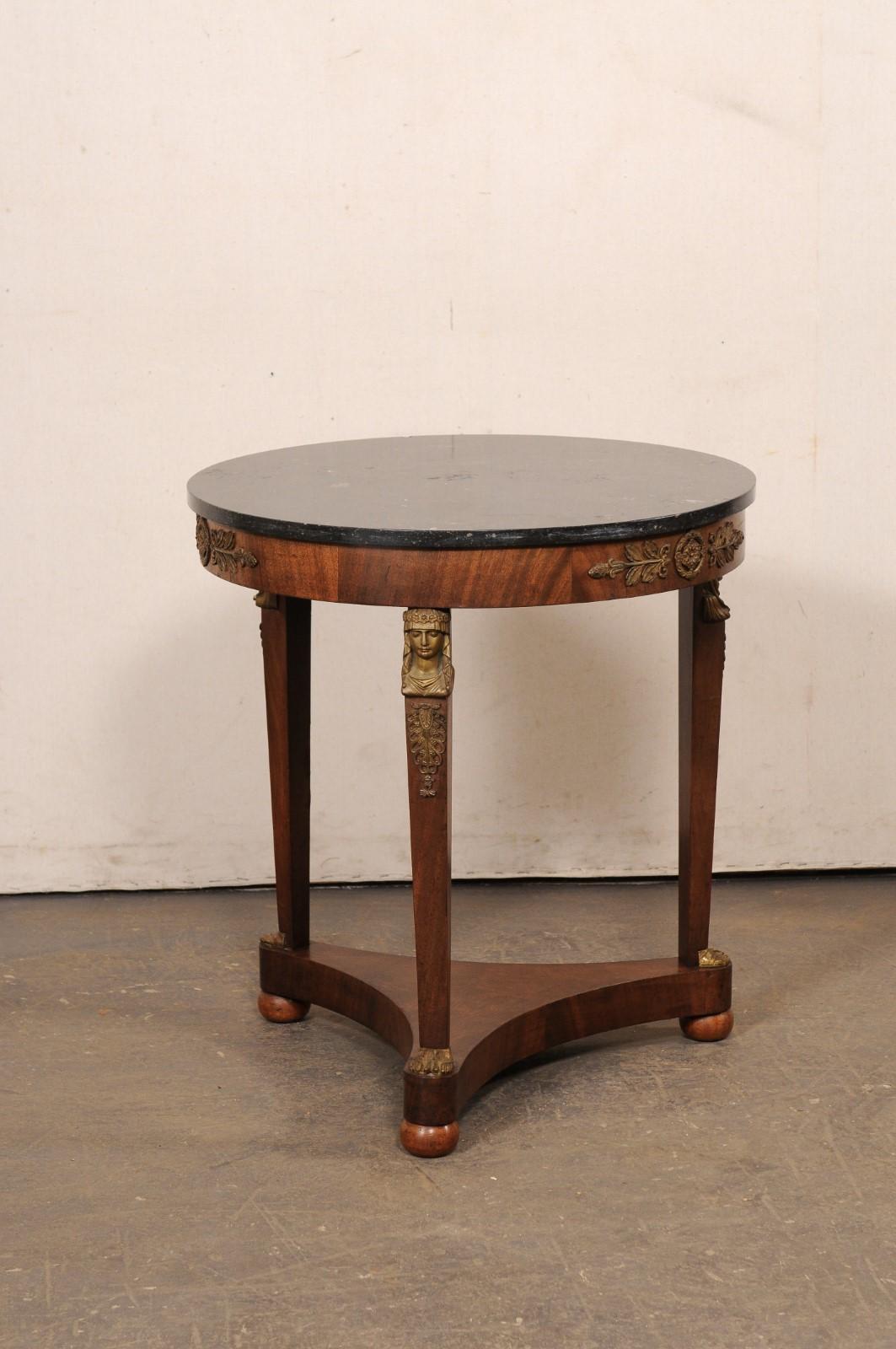 Runder französischer Beistelltisch im neoklassizistischen Stil mit schwarzer Marmorplatte und Akzenten der Renaissance aus dem frühen 19. Jahrhundert. Dieser antike Tisch im Guéridon-Stil aus Frankreich hat eine runde Marmorplatte, die sich über der