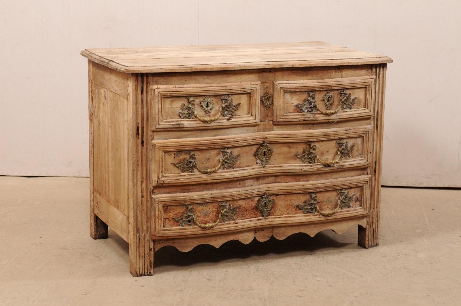 A French period Rococo commode, with subtle scalloped front, from the 18th century. This antique Rococo chest from France has a lightly-scalloped shape along its front, with top carved to mimic the shape of the case below, which houses a pair of