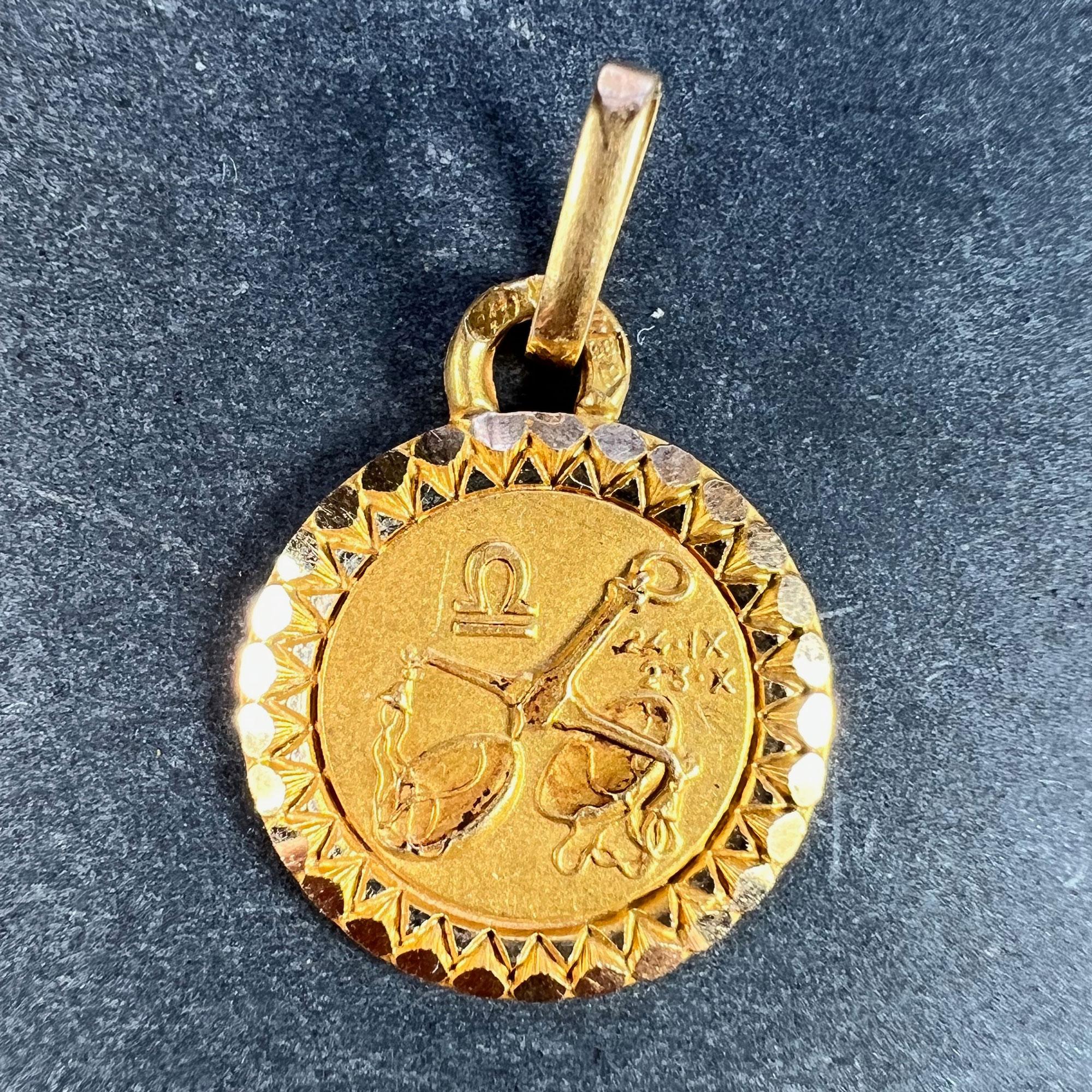 An 18 karat (18K) yellow gold charm pendant designed as the Zodiac sign of Libra, depicting a set of balance scales with the dates 24 IX (September) and 23 X (October). Stamped with the eagle mark for 18 karat gold and French manufacture with makers