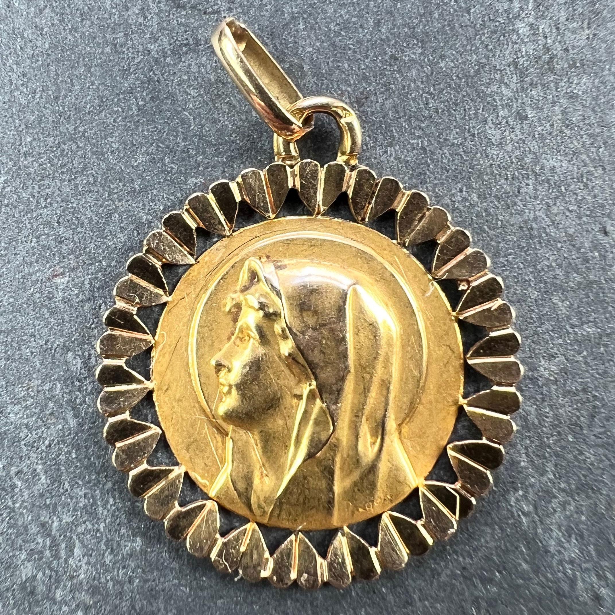 A French 18 karat (18K) yellow gold charm pendant designed as a round medal depicting the Virgin Mary within a frame of hearts. Stamped with the eagle's head for French manufacture and 18 karat gold, and maker's mark for Perroud. 

Dimensions: 2.4 x